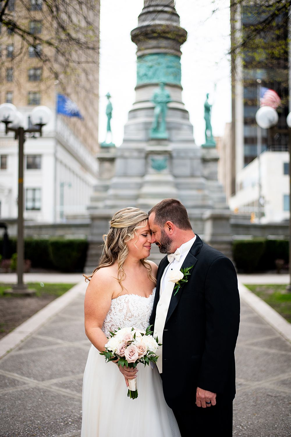 Newlywed couple sharing an intimate moment in front of the Soldiers and Sailors Monument in downtown Indianapolis.