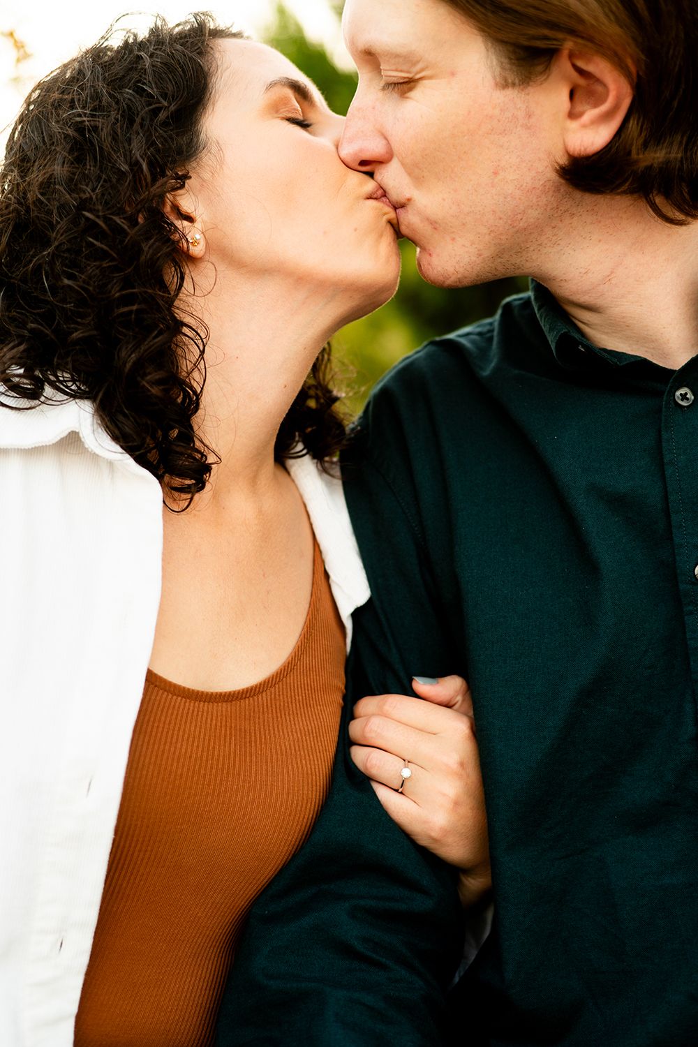 A romantic couple embraces intimately in a series of tender kissing moments against a natural backdrop.