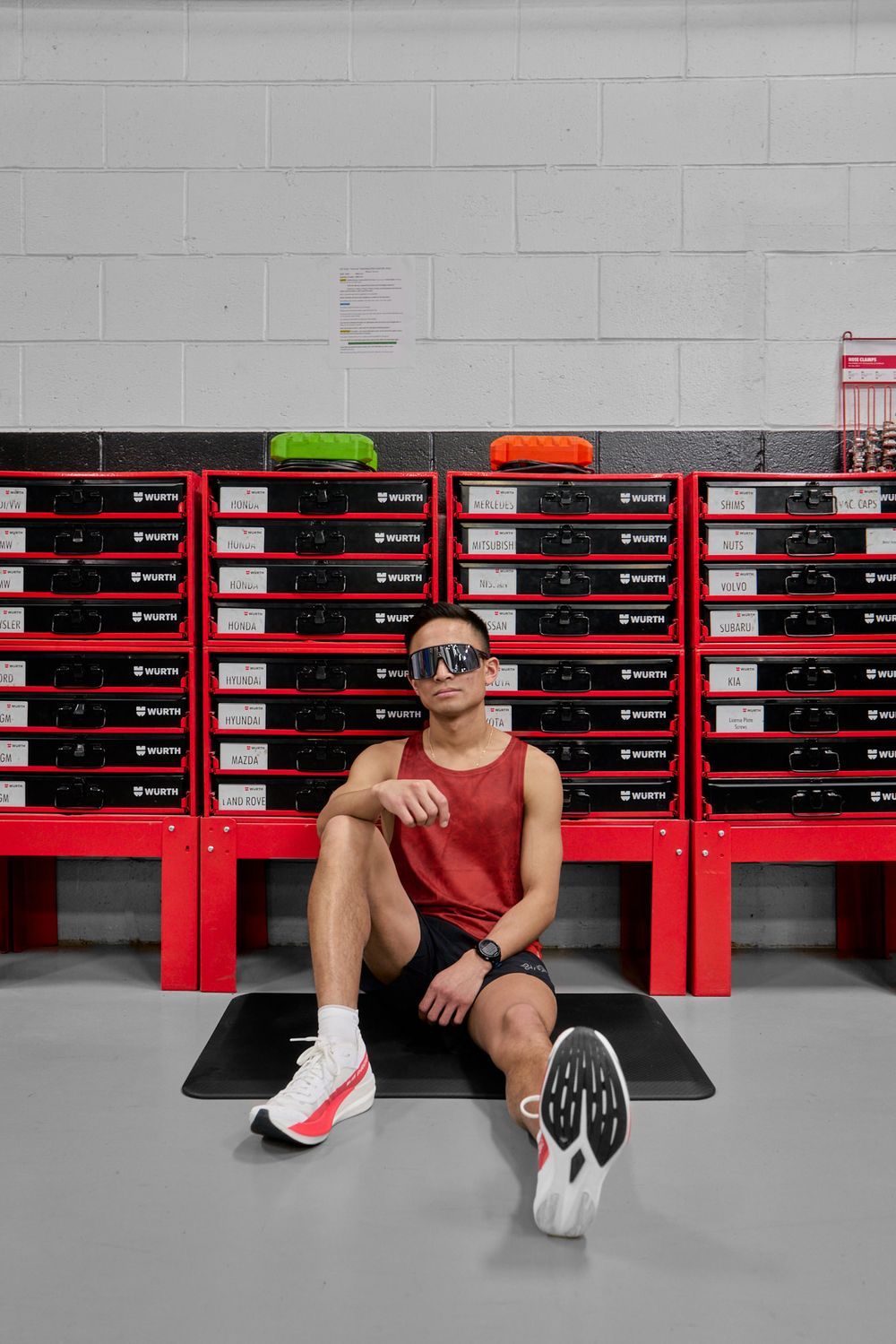 A man sits cross-legged on the floor, facing a vibrant red storage unit, creating a cozy and casual atmosphere.