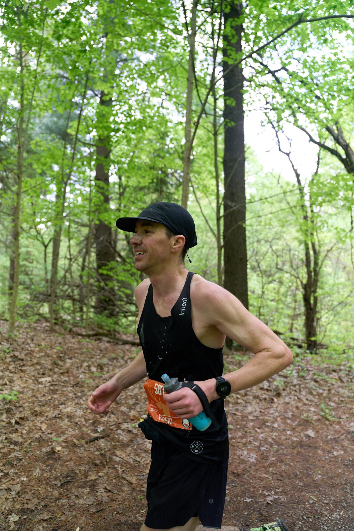 A man sporting a hat and red shorts jogs on a road, illustrating a scene of exercise and vitality.