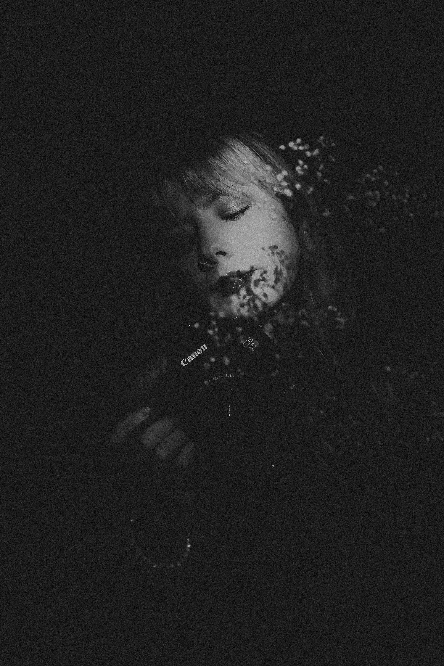 Moody black and white portrait with delicate floral shadows.