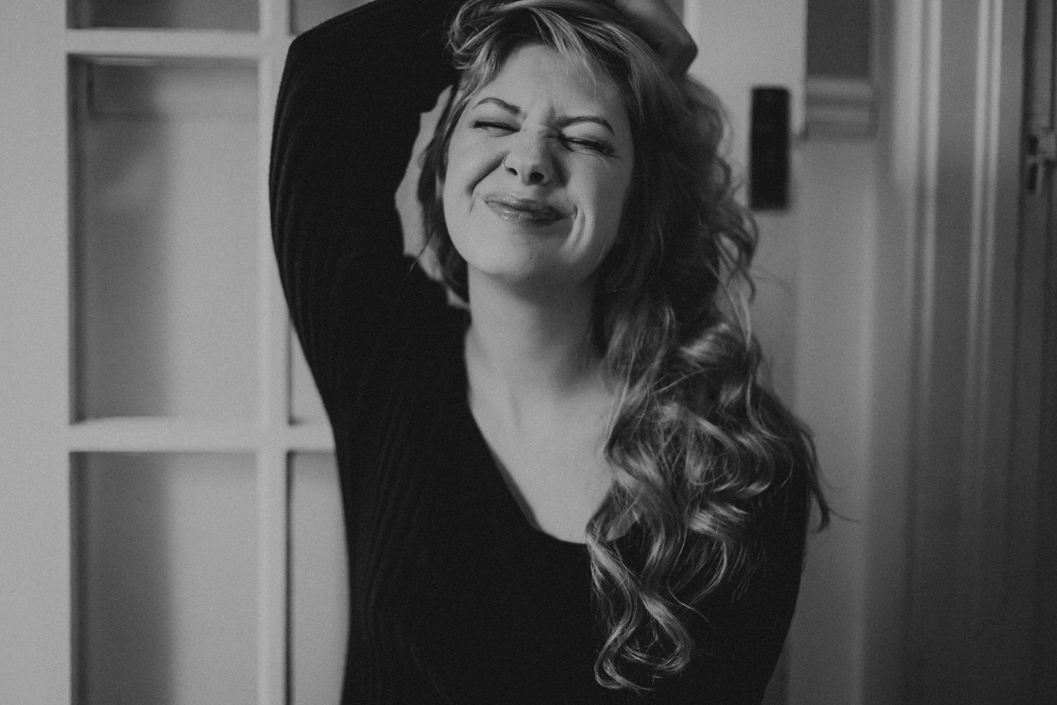 Black and white portrait with curled hair and dramatic lighting.