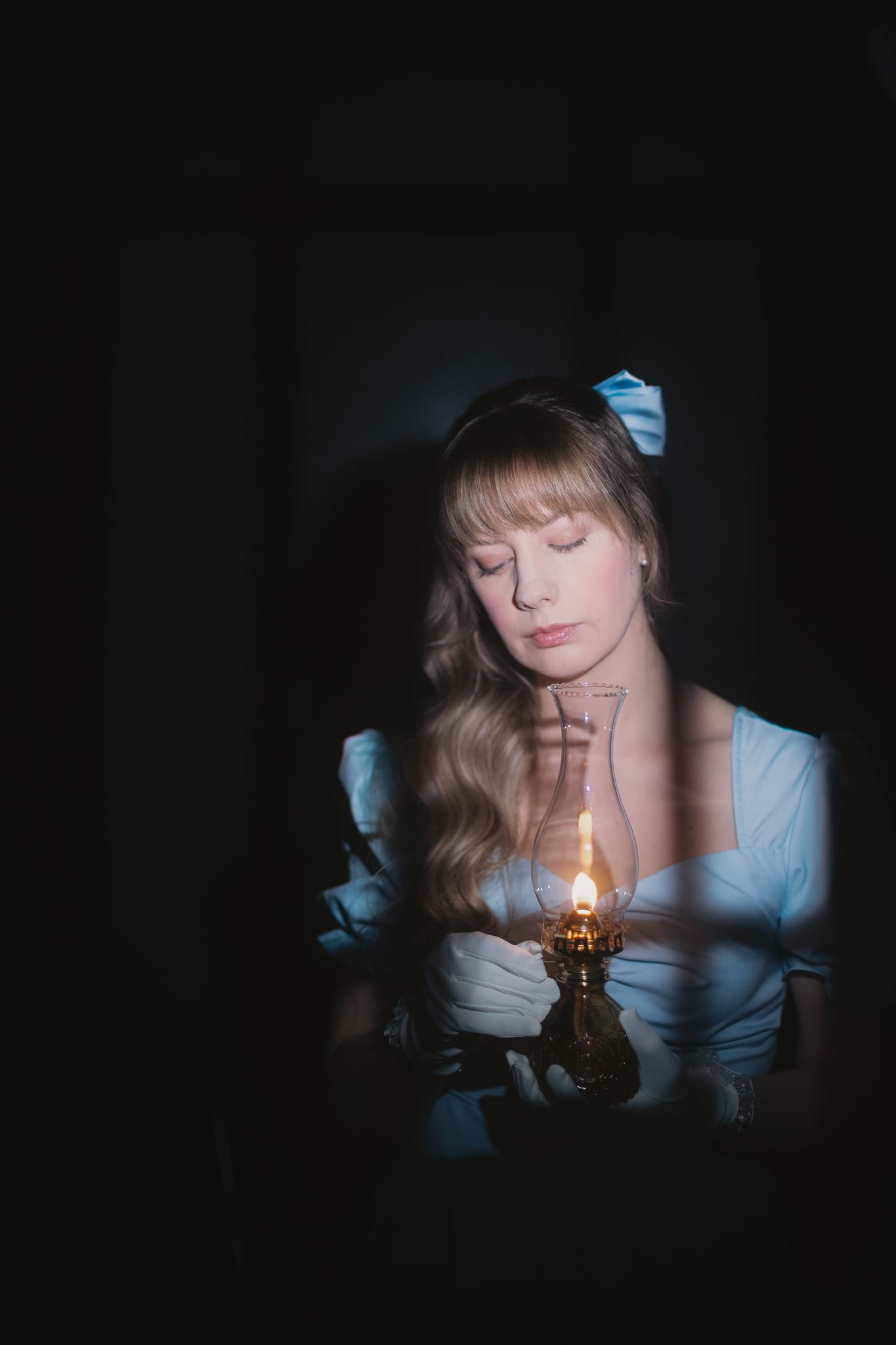 Romantic candlelit portrait in a vintage-style blue dress.