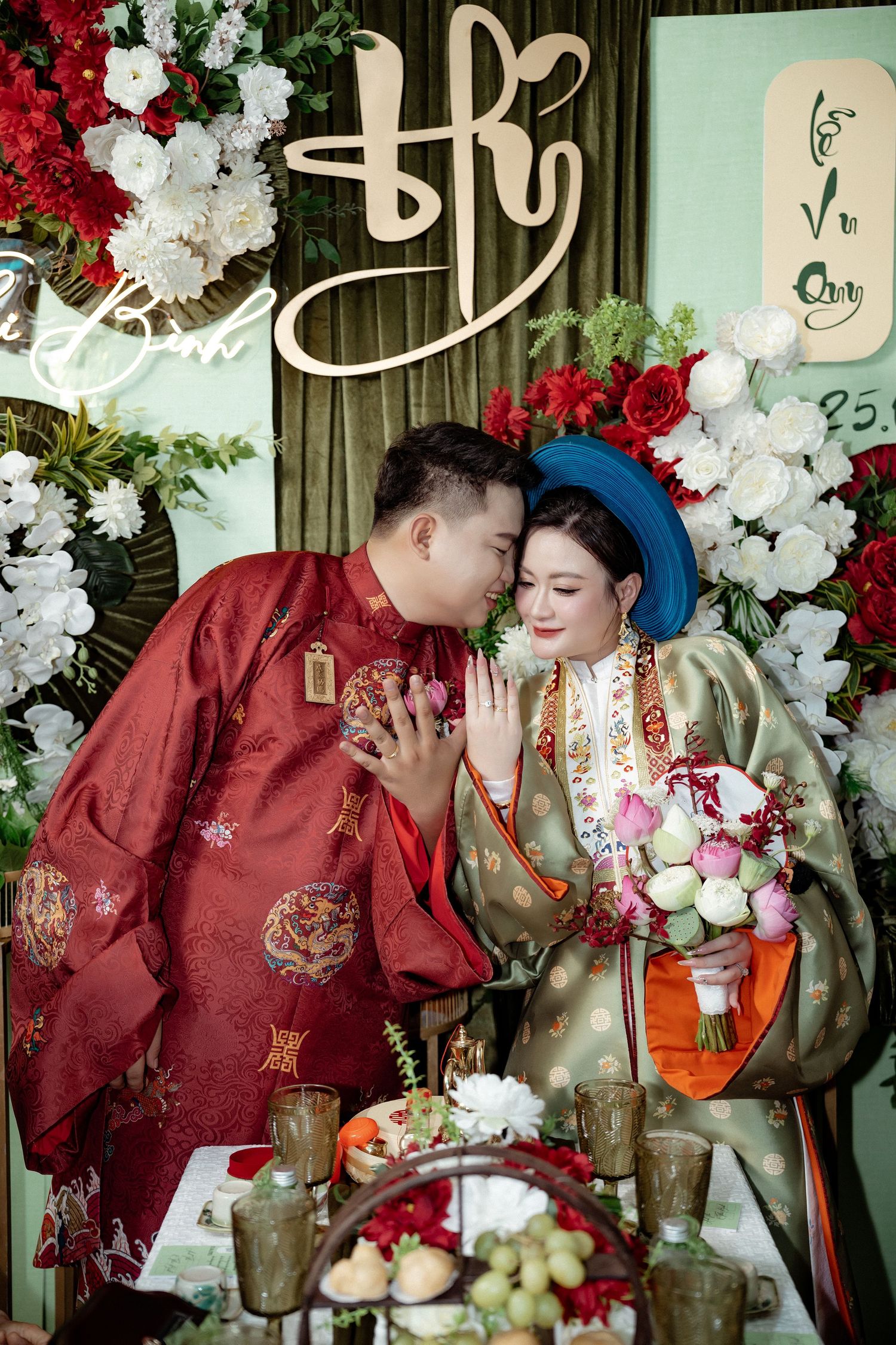 Traditional Vietnamese wedding celebration with decorative floral arch, traditional ao dai attire, and banquet table setting.