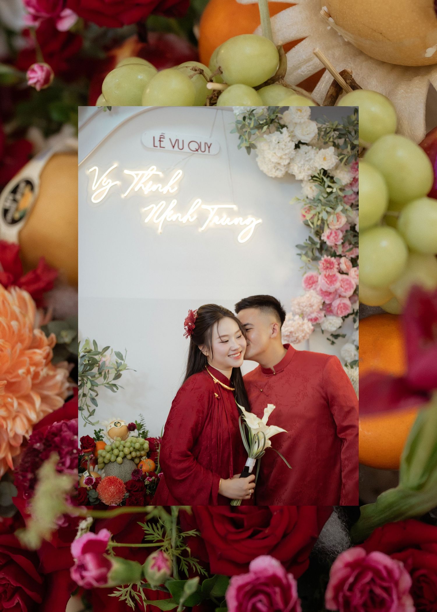 A romantic photo framed with fruits and flowers shows a couple in matching red outfits embracing against a floral backdrop.