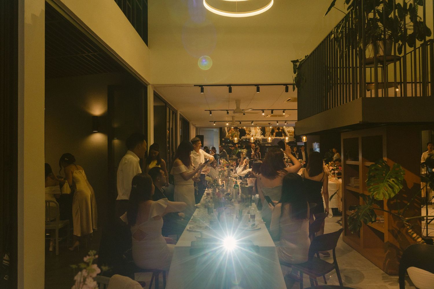 People gathered in a dimly lit restaurant with ambient lighting creating a warm, cozy evening atmosphere.