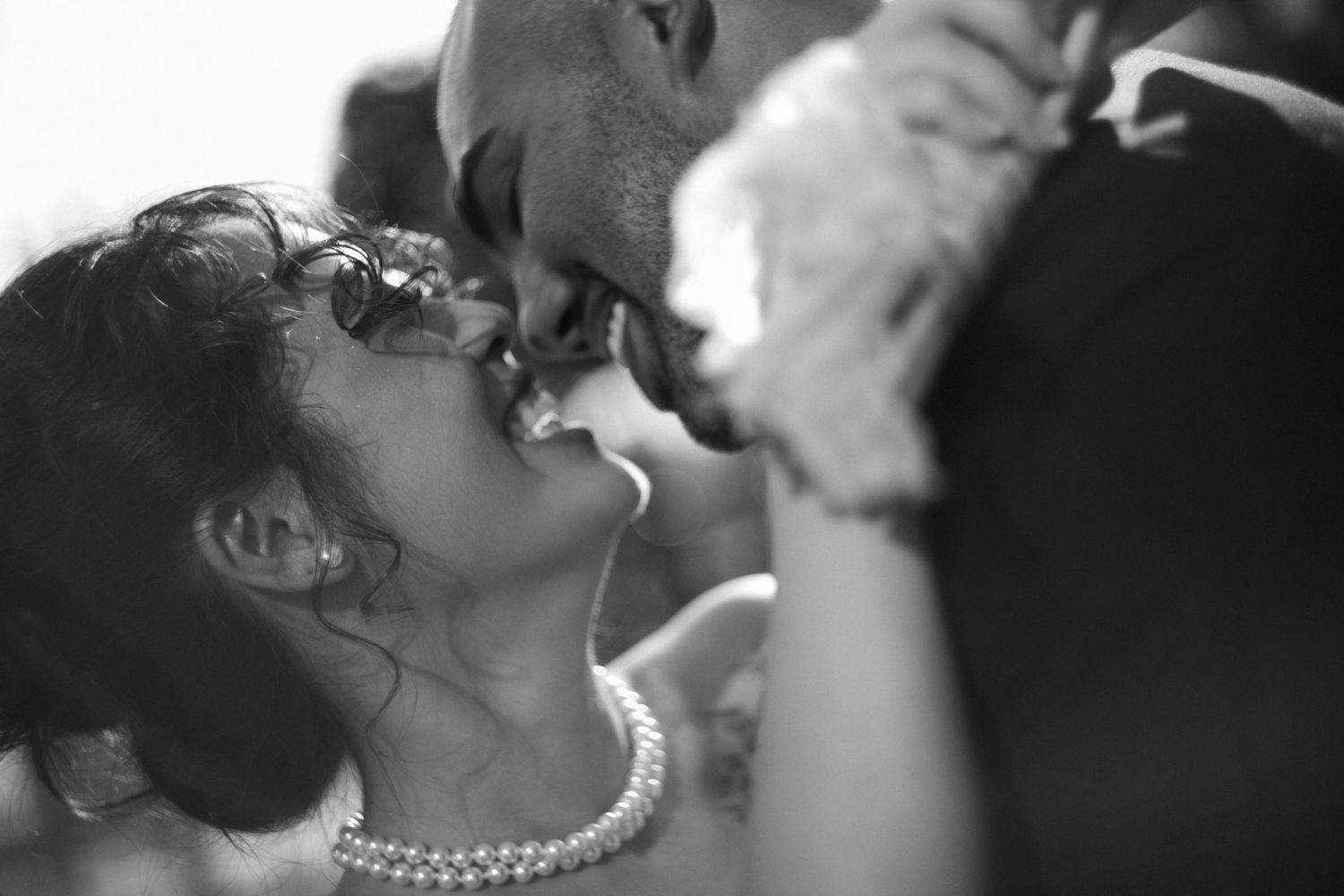 A close-up black and white photo of a romantic moment between newlyweds.
