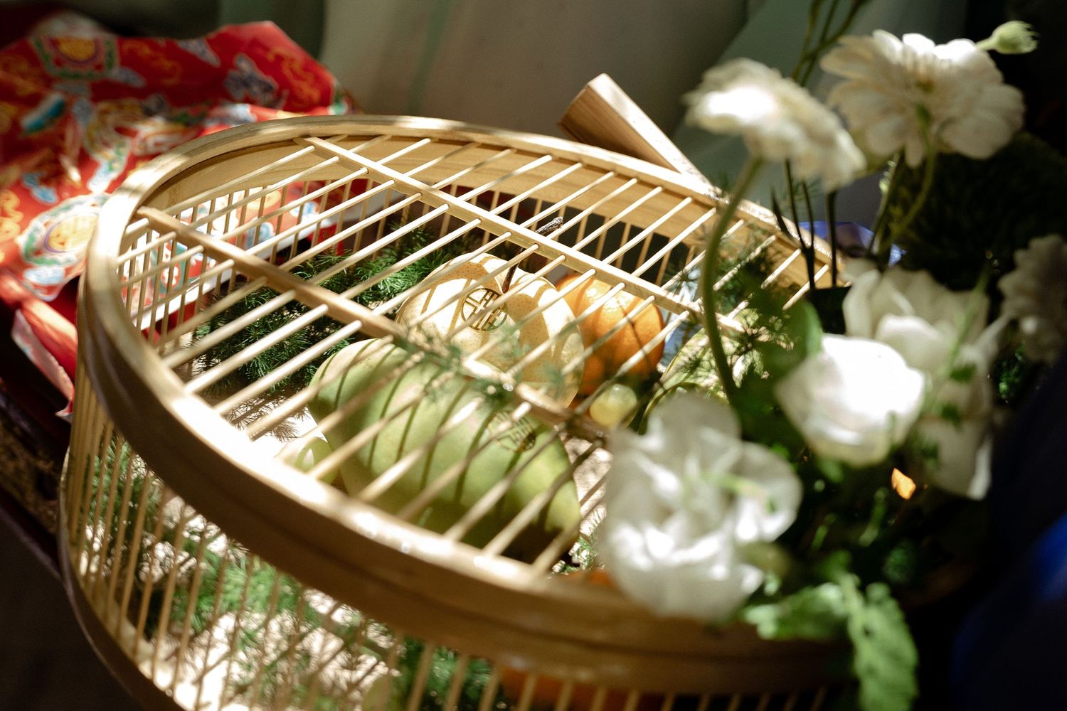 A decorative gold birdcage sits among white roses at a wedding reception.