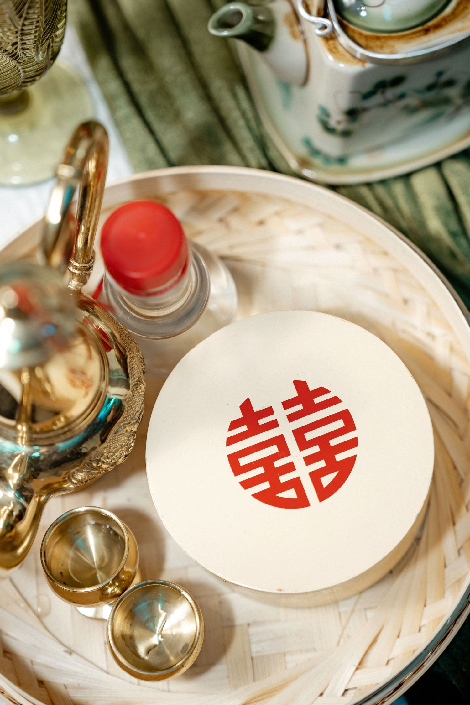 Traditional Chinese double happiness symbol on a white box with teacups and serving items on an ornate tray.
