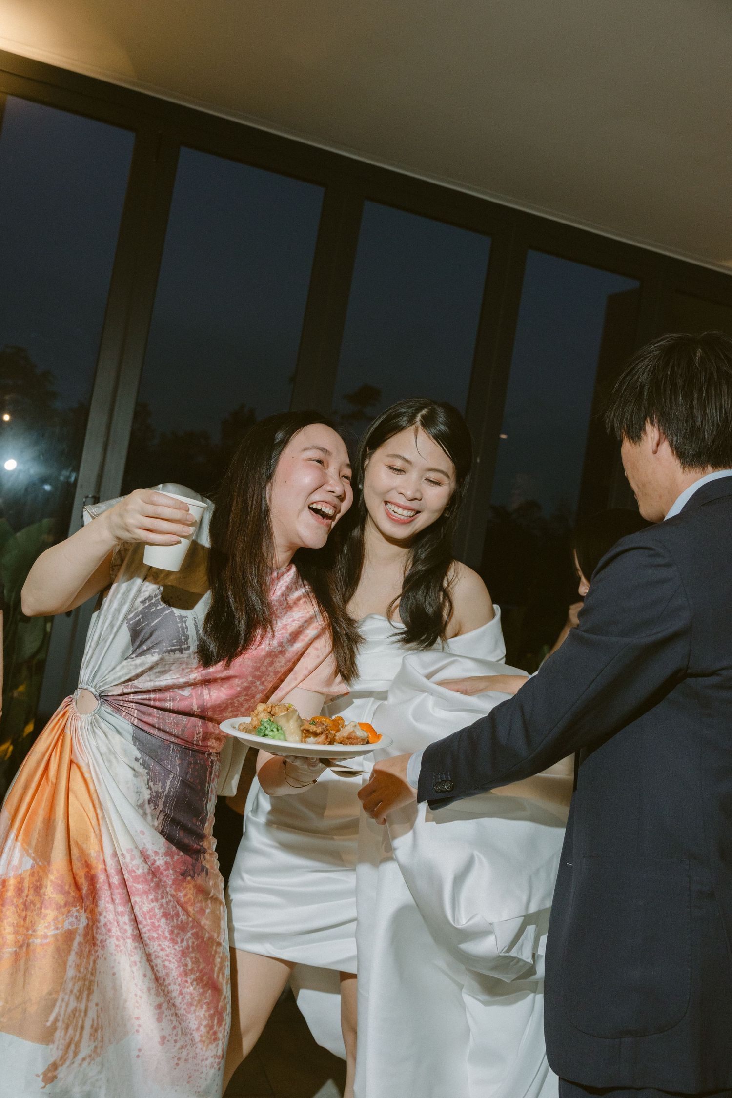 A group of party guests laugh and dance together during a celebration event.