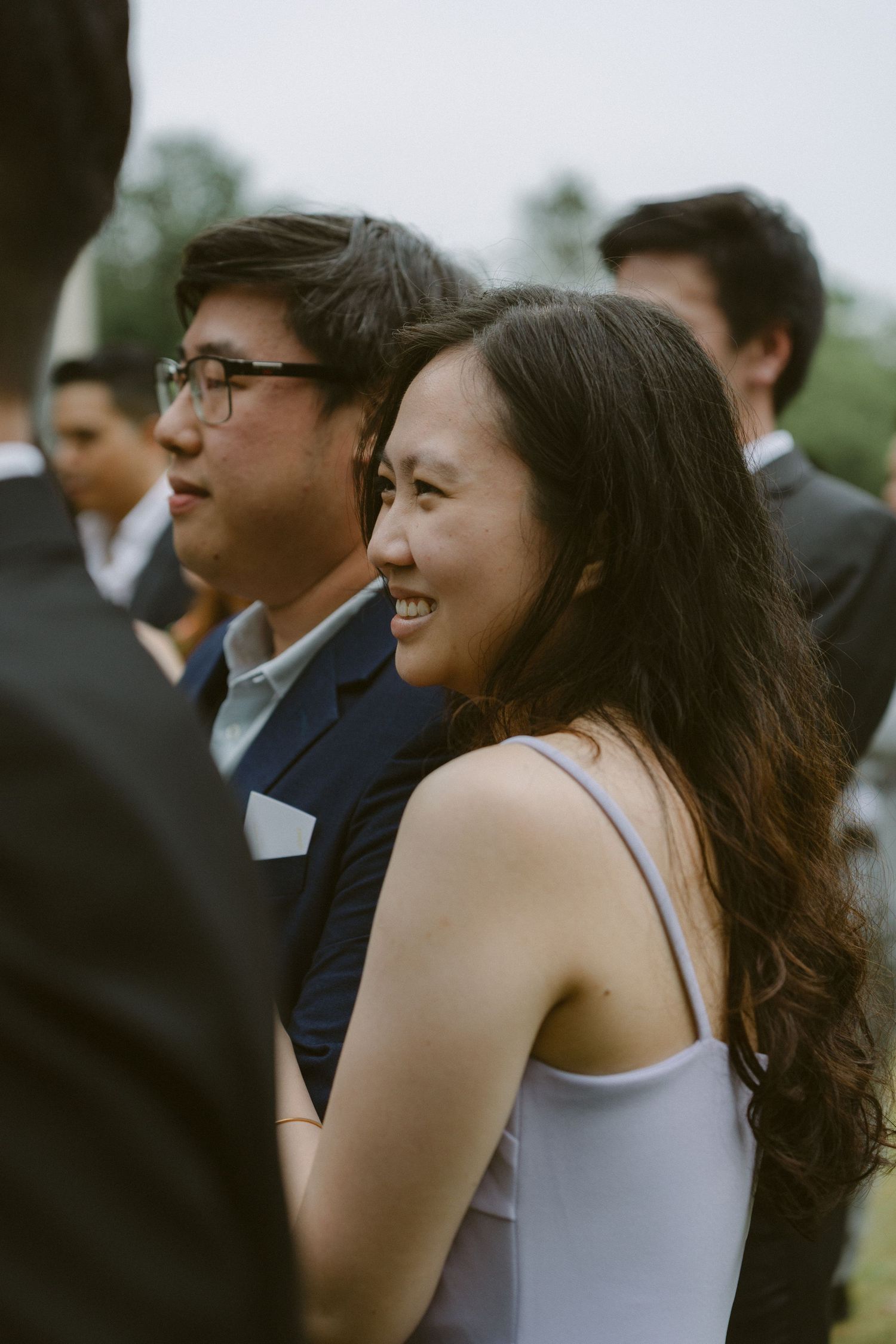 Event guests in formal attire standing together during an outdoor gathering.