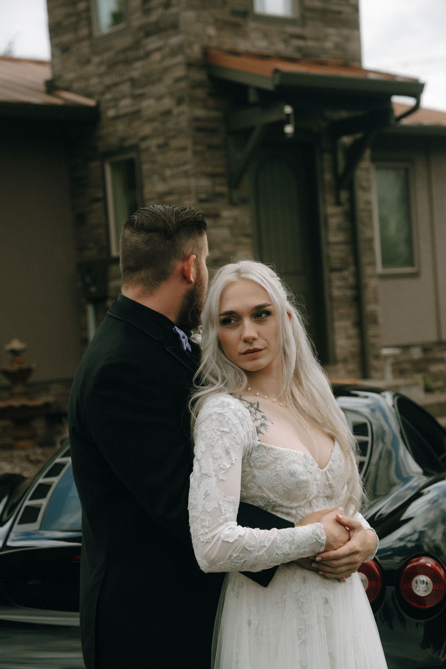 Wedding couple shares intimate moment outside stone building.
