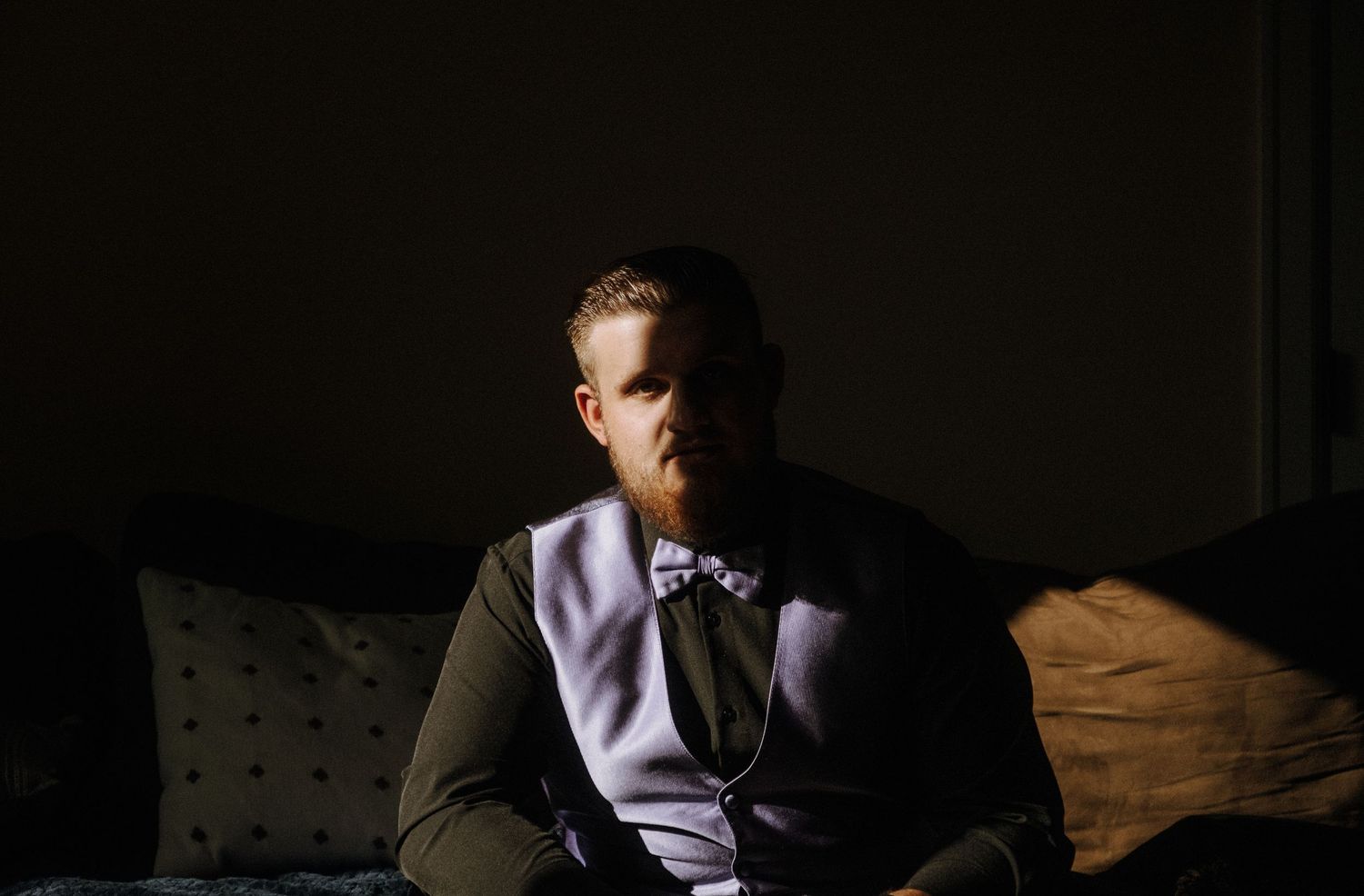 A series of dramatic portrait photos in dark lighting shows someone sitting with deep shadows and dramatic contrasts.