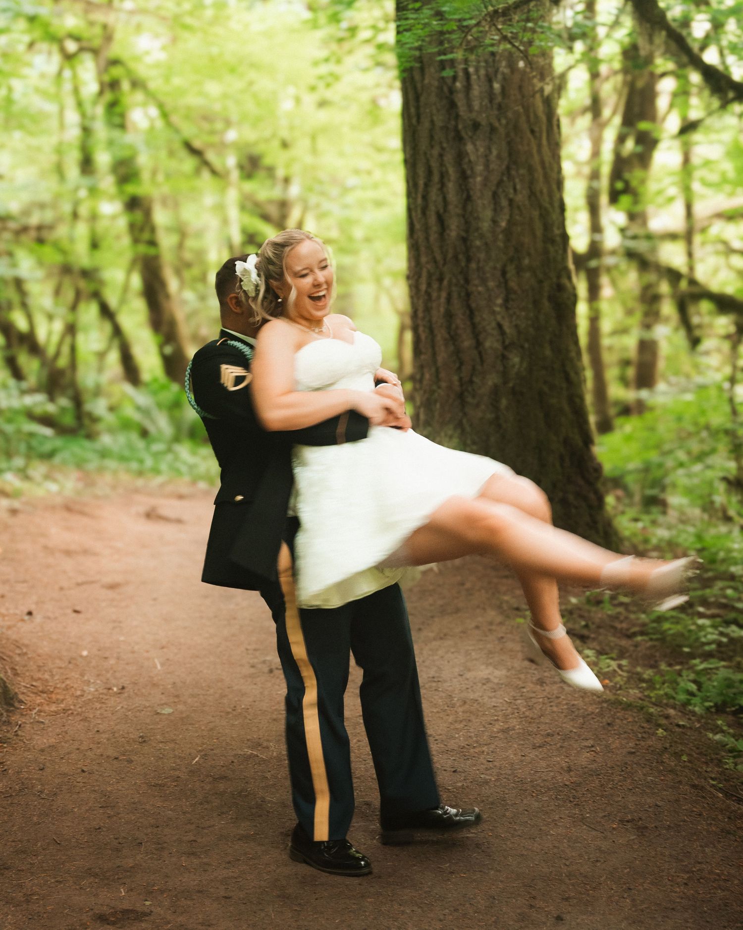 Romantic dance sequence on a forest path with pine trees creating natural backdrop.