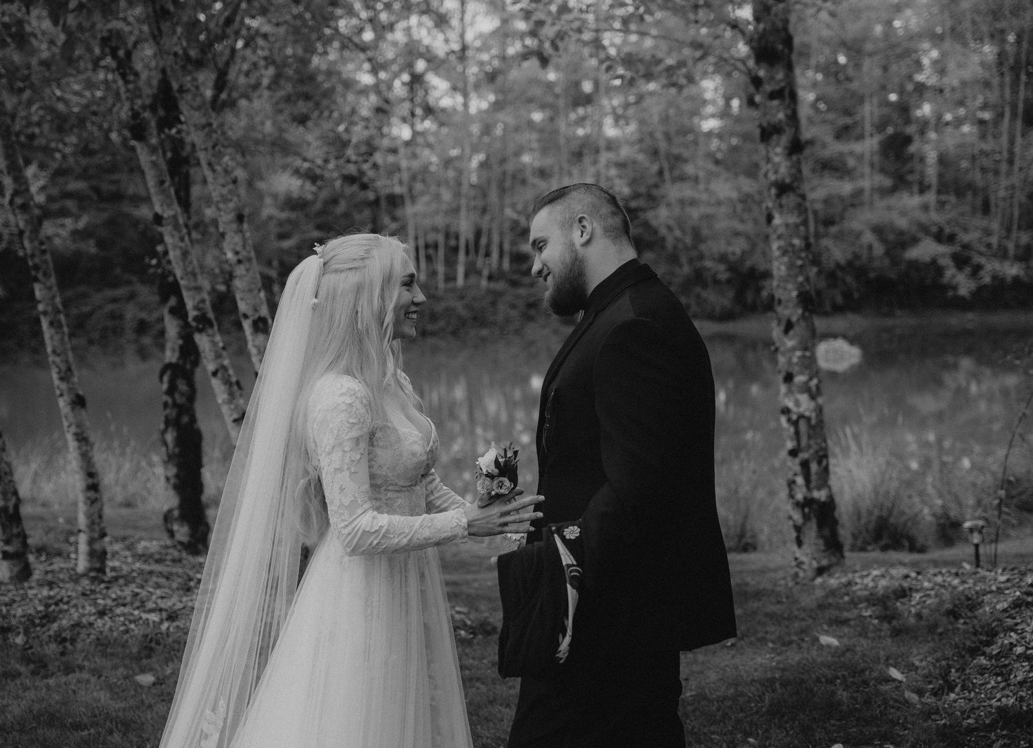 A black and white wedding photo series showing intimate moments between a couple in a romantic forest setting.