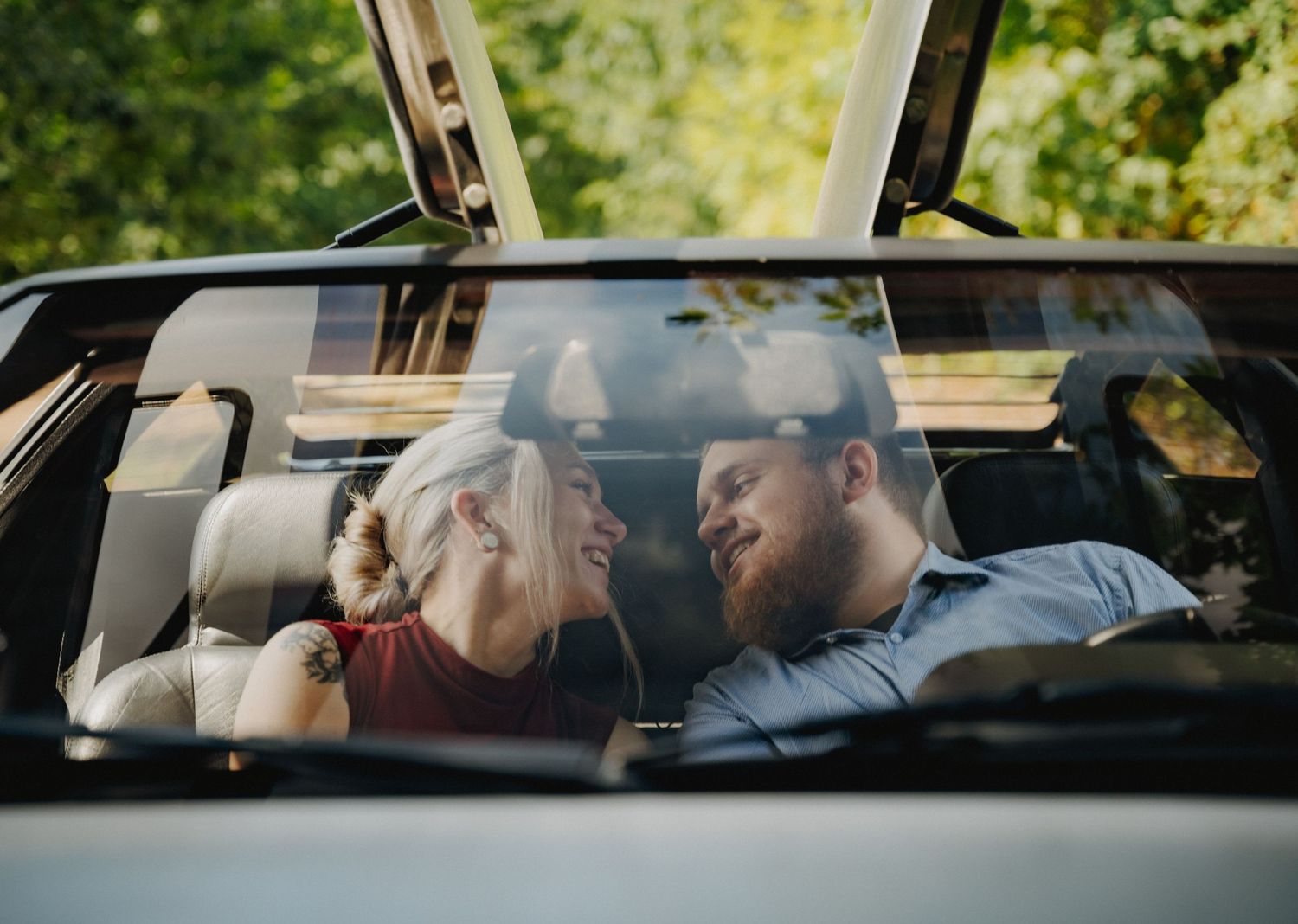 A romantic moment viewed through a car window showing affection between a couple.