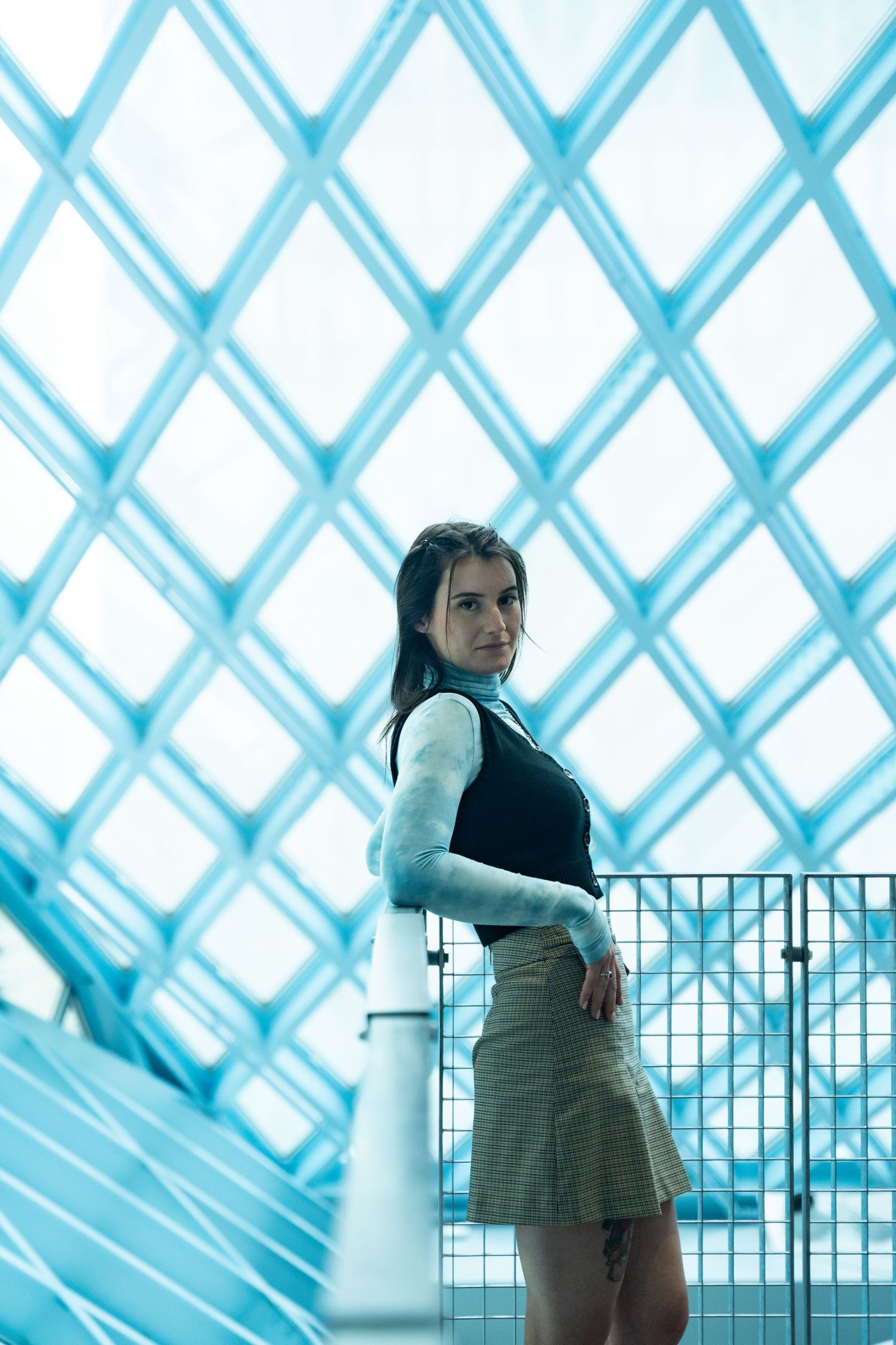 A fashion photo series showing model poses against a geometric blue and white lattice backdrop.