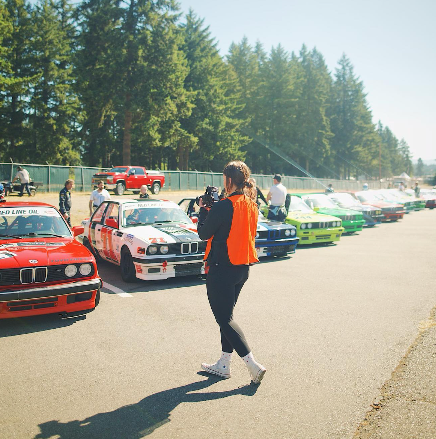 Colorful vintage BMW cars lined up at an outdoor automotive event.