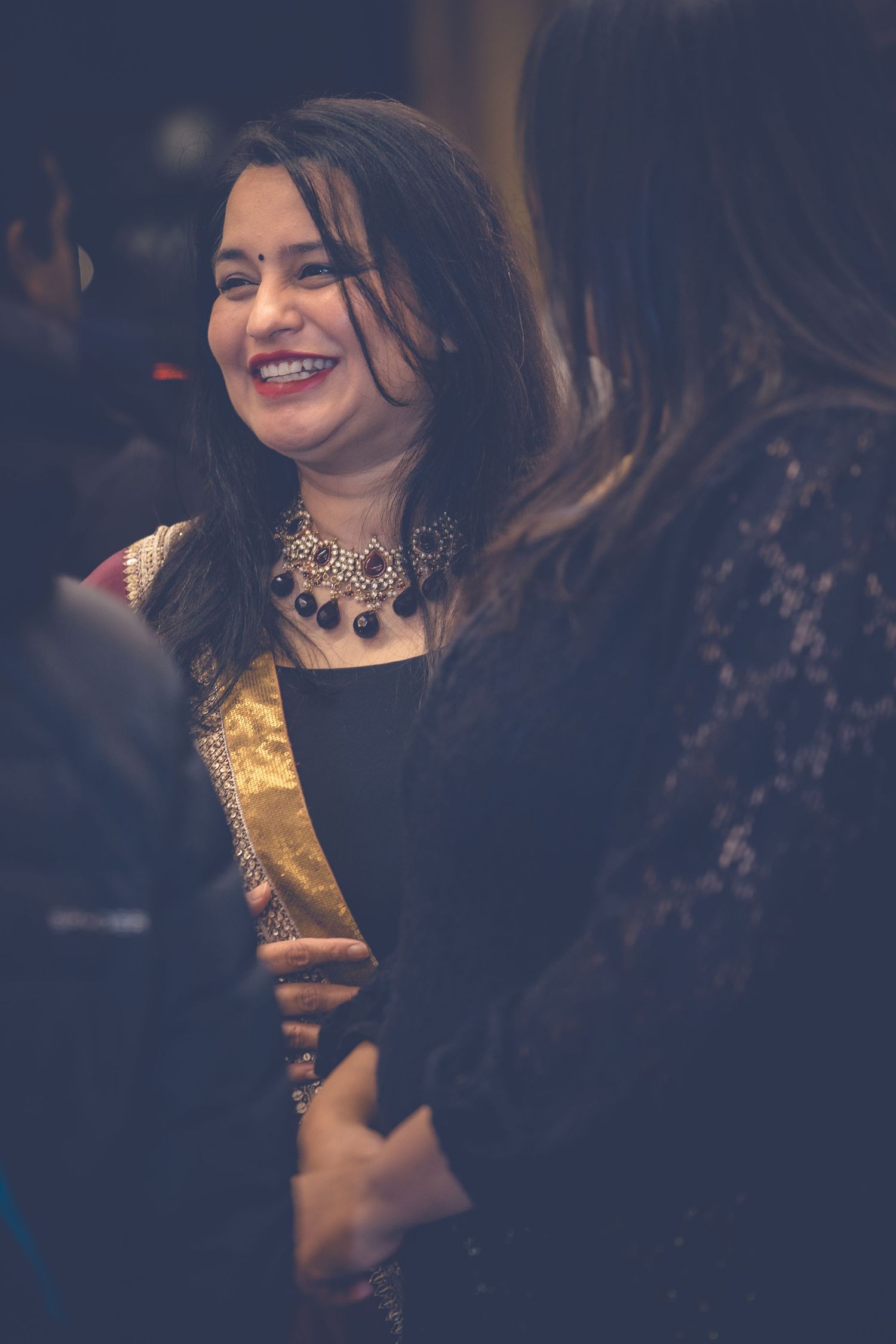 Woman in formal attire laughing during an evening celebration.