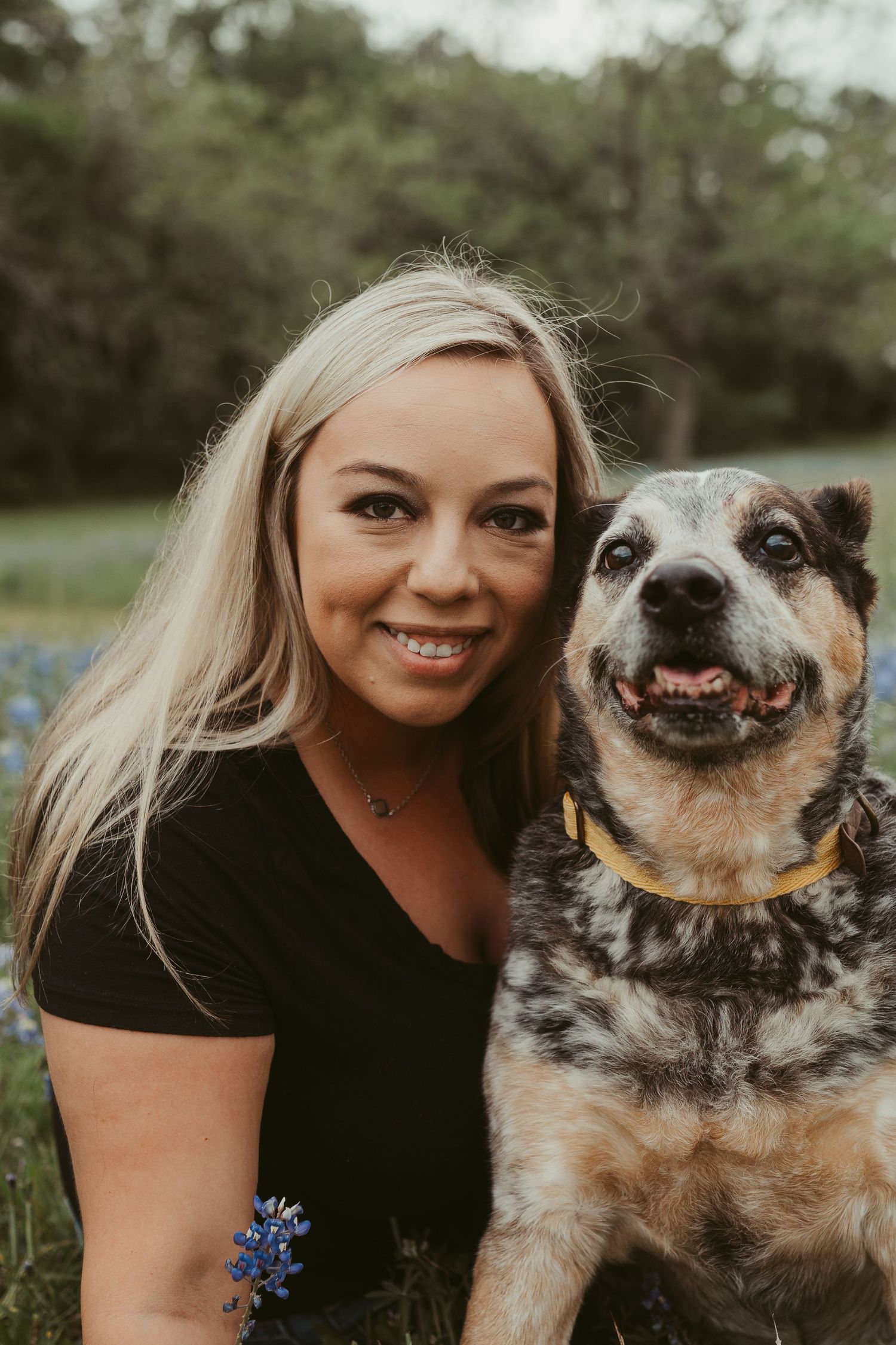 A woman and her aging dog embrace for a photo in the Texas bluebonnets