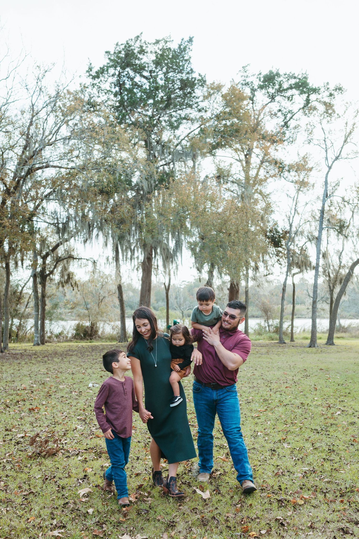 A beautiful family smiles and hugs during their session at a local park
