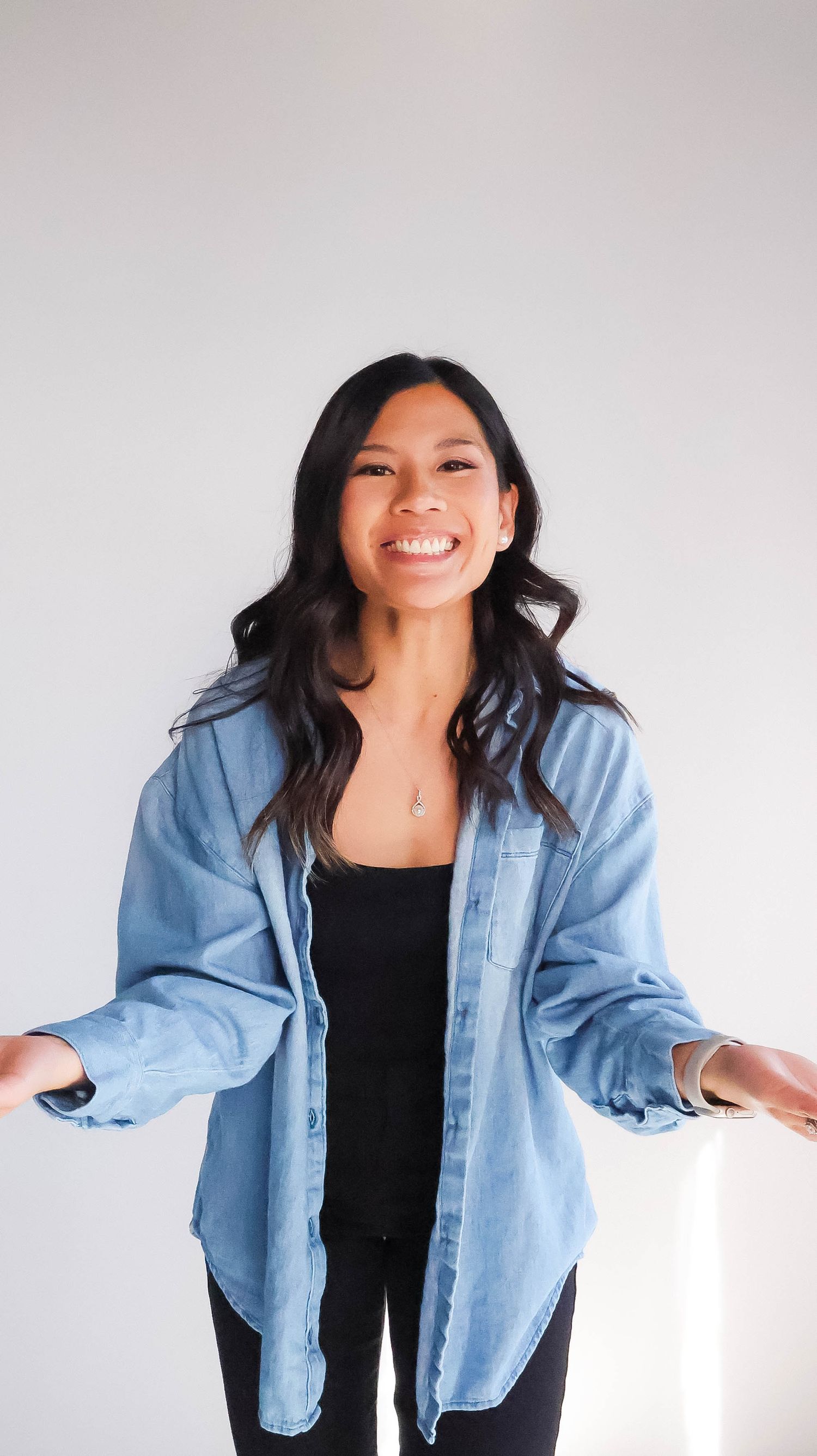 girl wearing a blue button up smiling and excited