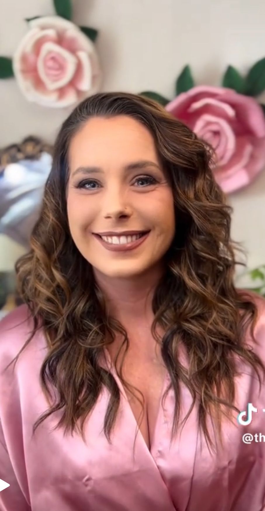 A Before and After photo series showing curled brown hair against a pink robe with soft pink roses in the background.