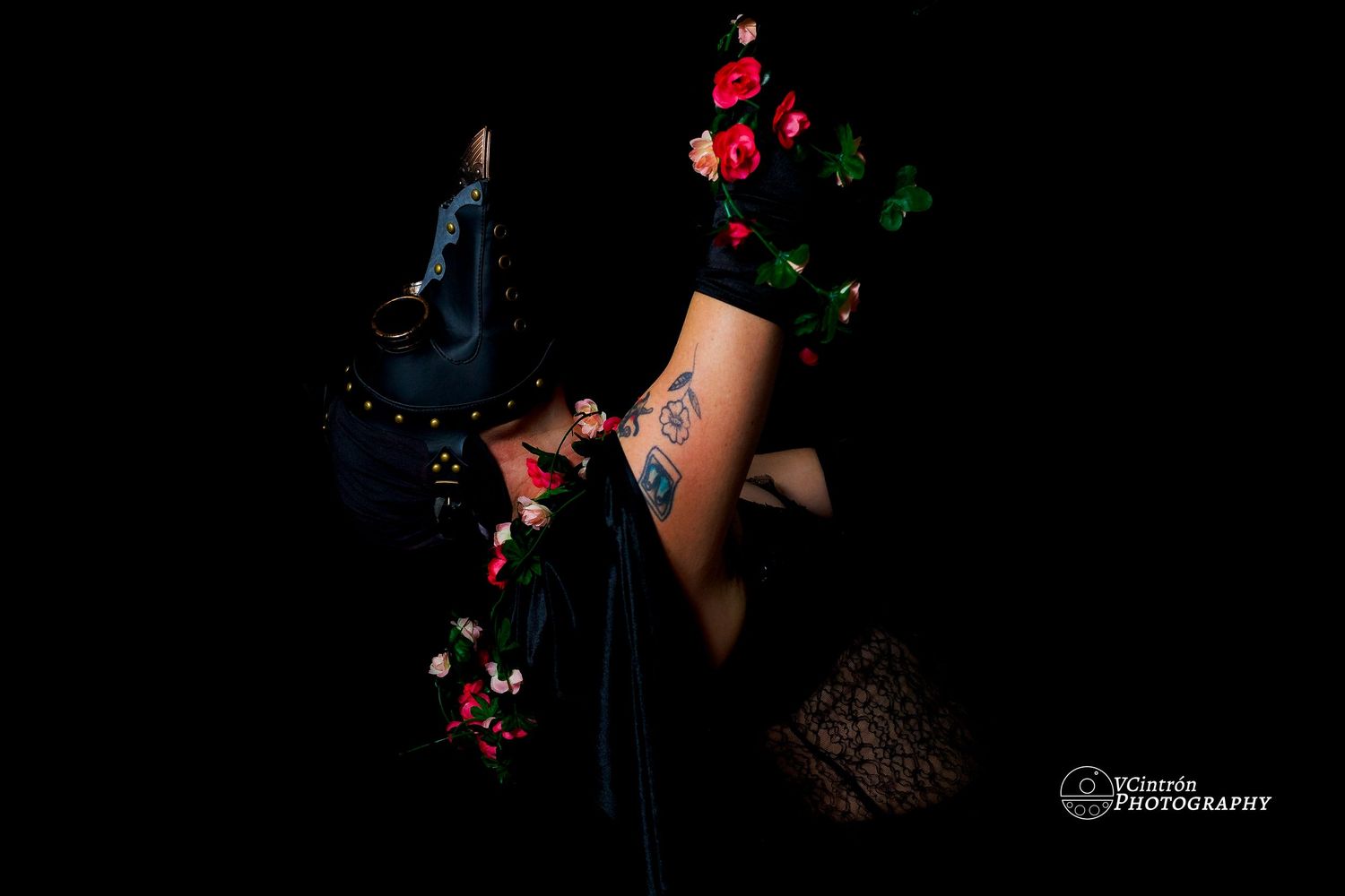 A person holding red and green lights while dancing in a dark studio setting.