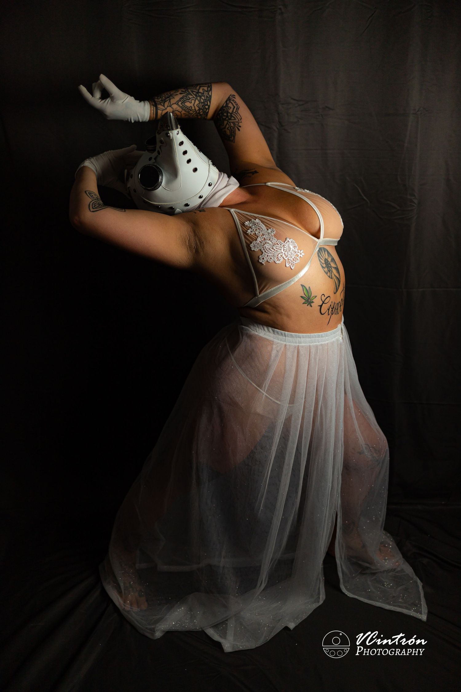 Artistic portrait series featuring delicate white lingerie and sheer flowing fabric against dark dramatic lighting.