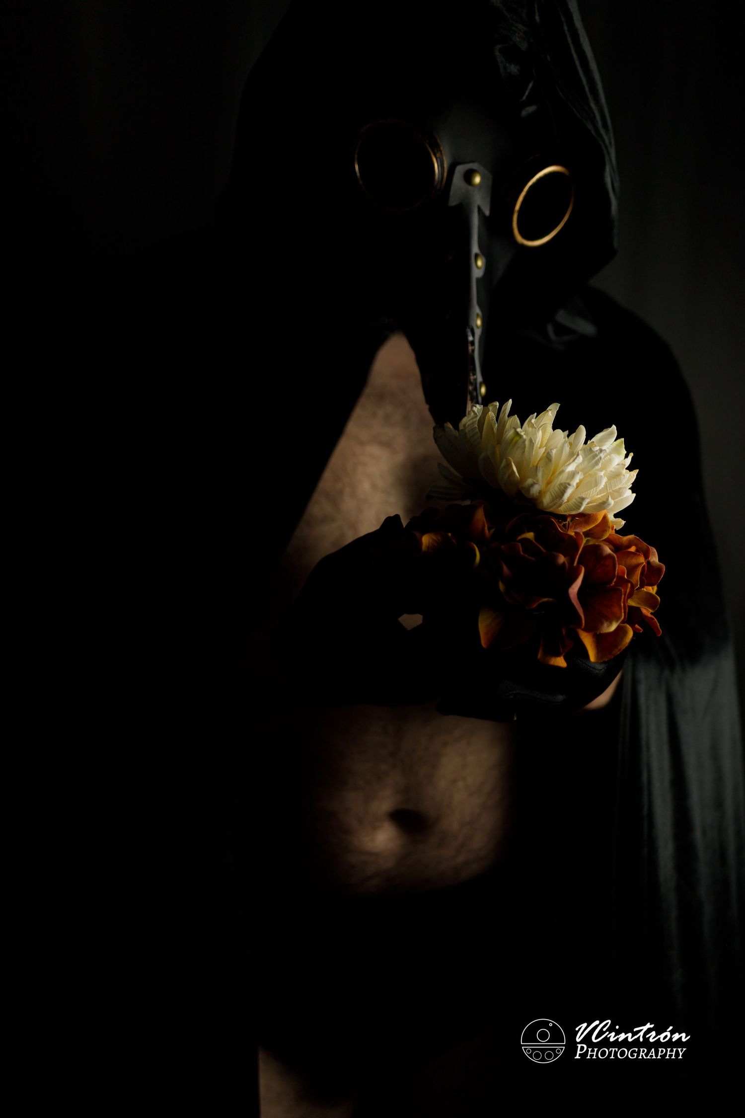 Dark artistic photo showing flowers against shadowy backdrop with moody lighting and dramatic contrast.