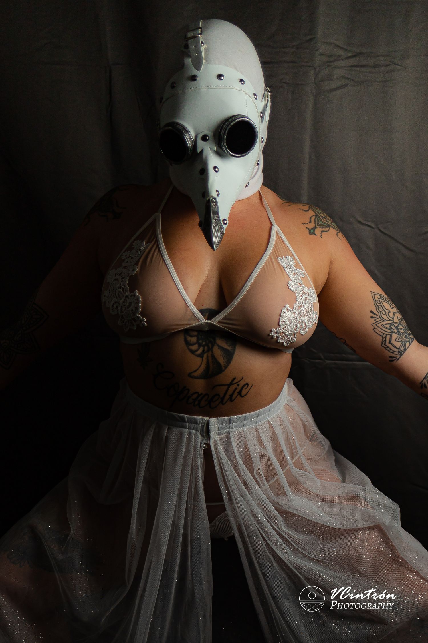 A figure wearing a white helmet and sheer dress poses dramatically in a progressive series of artistic boudoir photos.