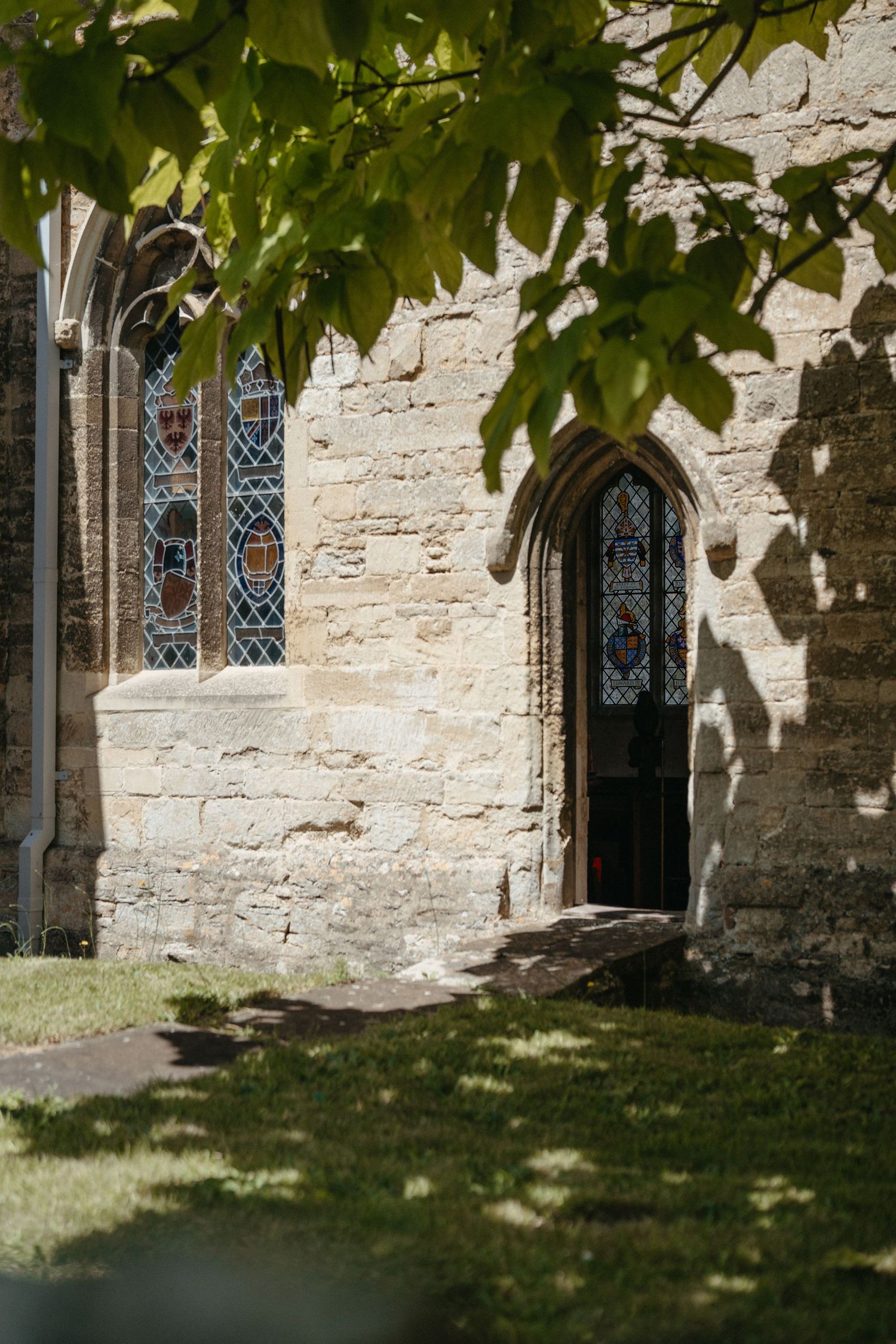 Medieval church windows with intricate stone details and leafy green vines.