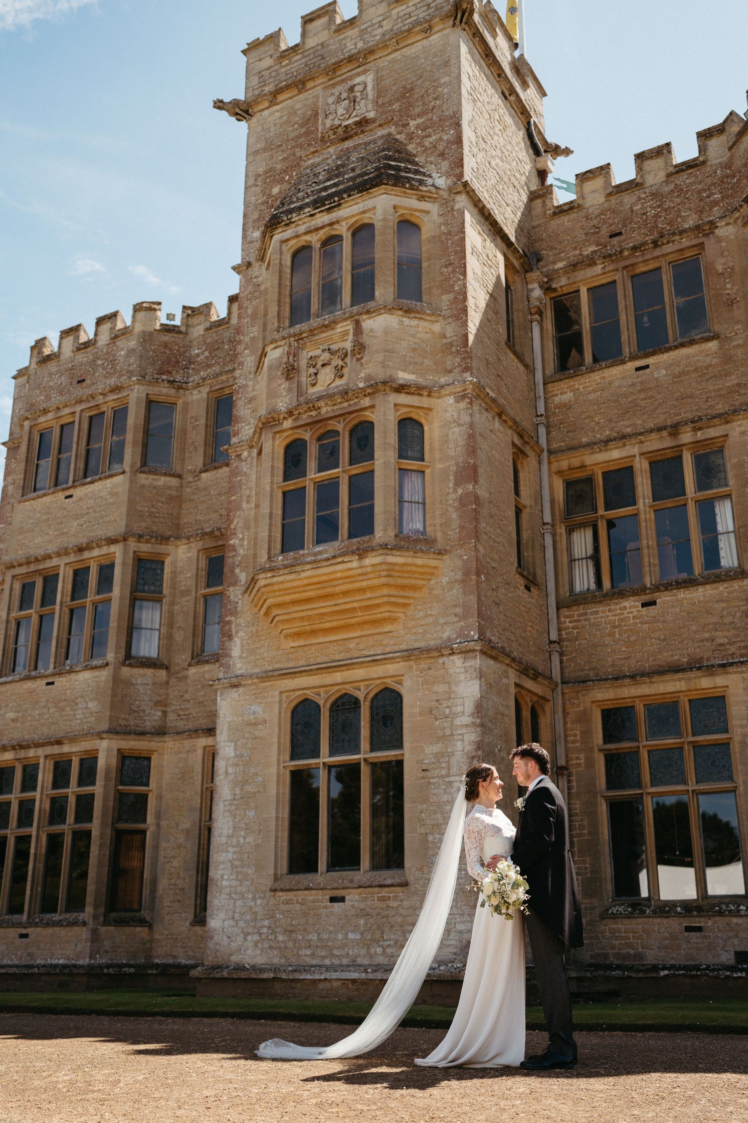 Majestic stone facade of a historic manor with ornate architectural details and tall windows.