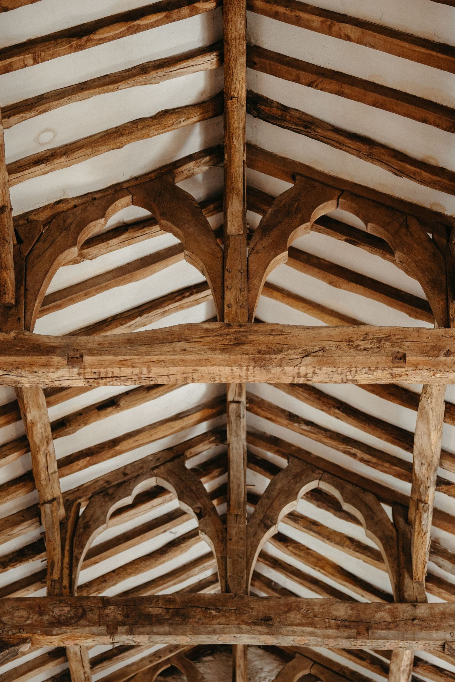 Exposed wooden beam ceiling structure in historic building showing traditional craftsmanship.