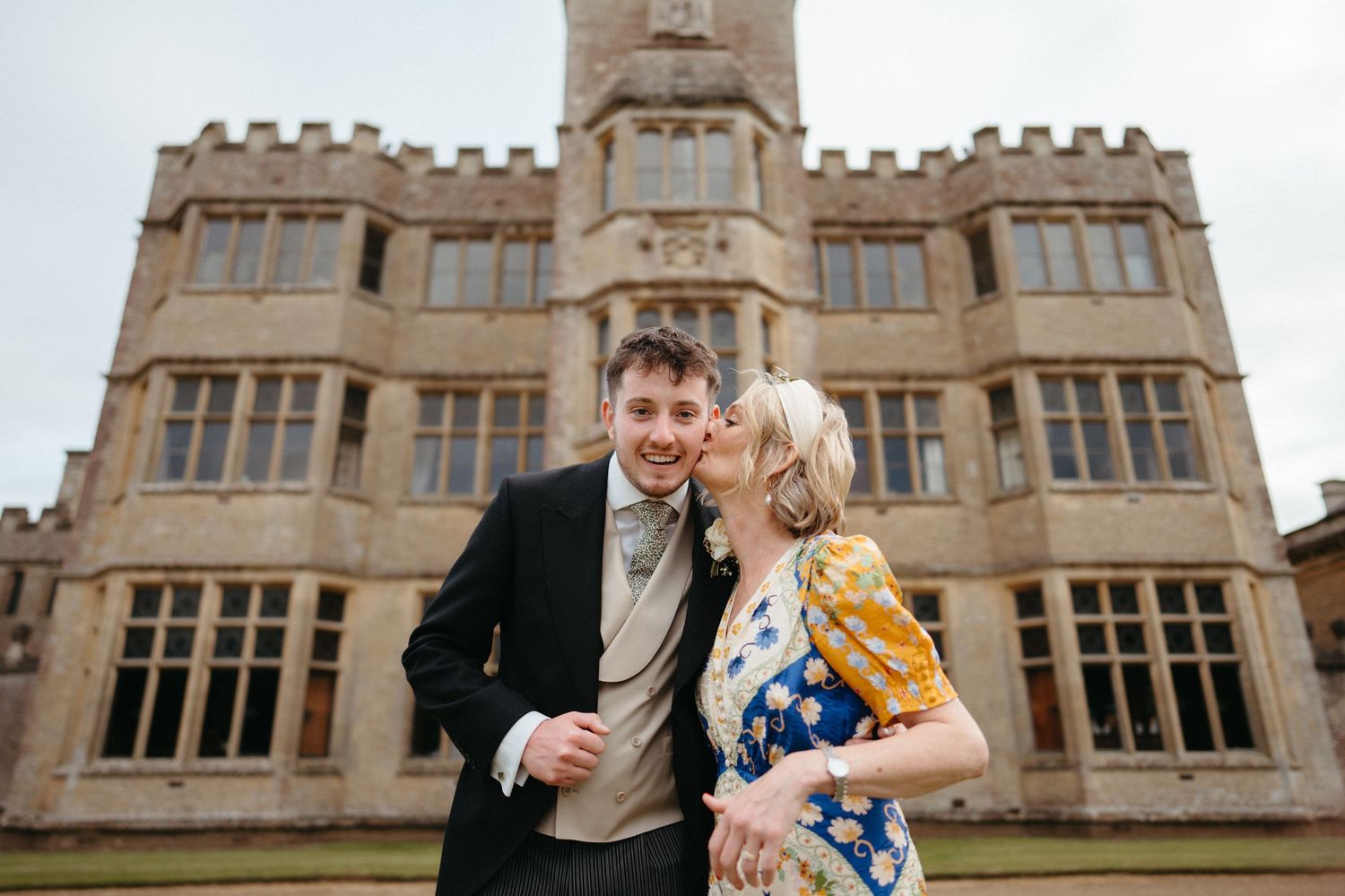 Grand stone castle-like venue with Gothic architecture serves as backdrop for wedding celebration.