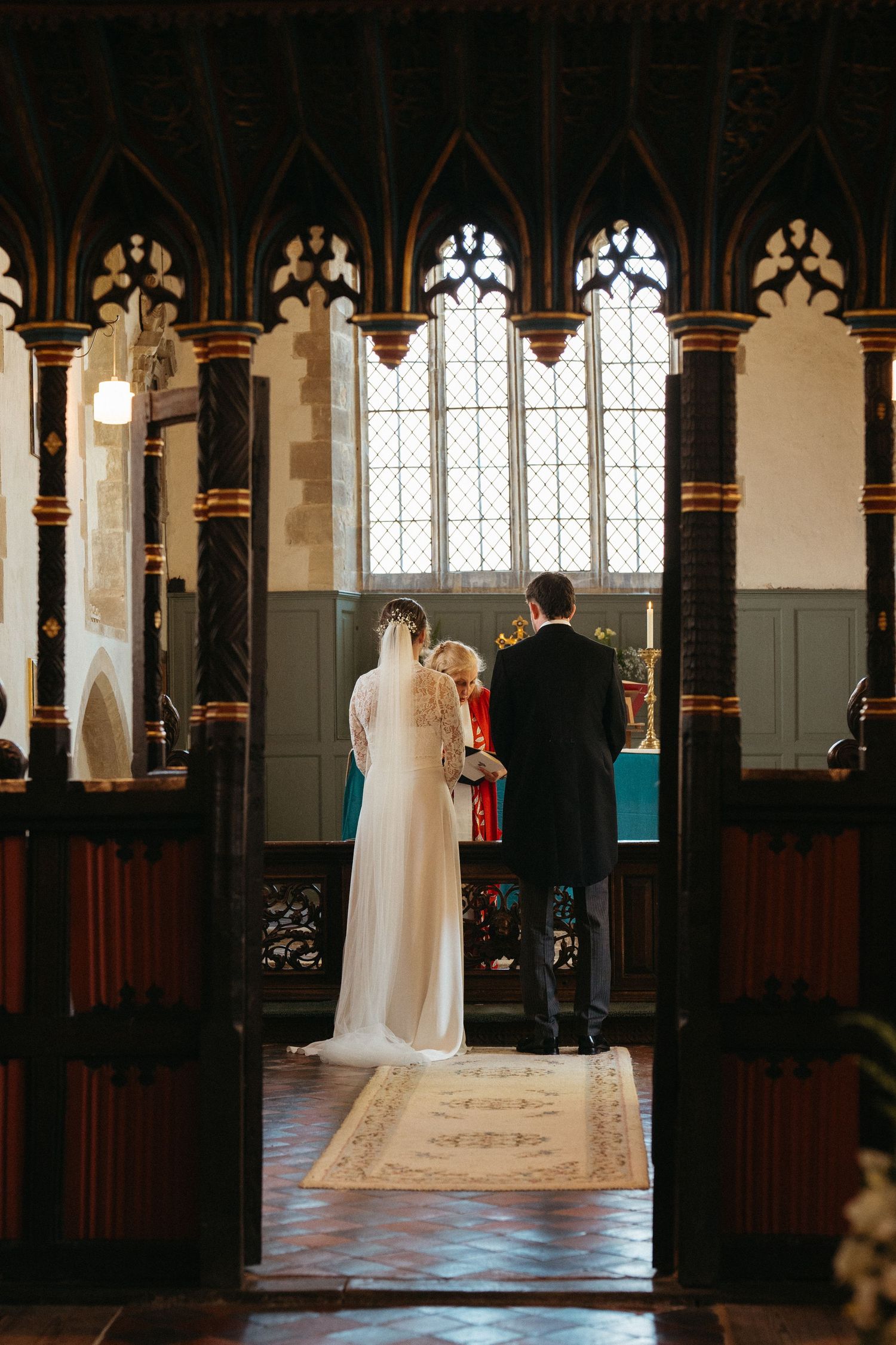 Gothic church interior with vaulted ceilings and stained glass windows illuminated in natural light.