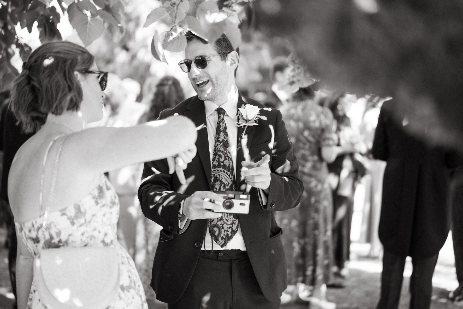 Wedding guests enjoying drinks and conversation during an outdoor reception.