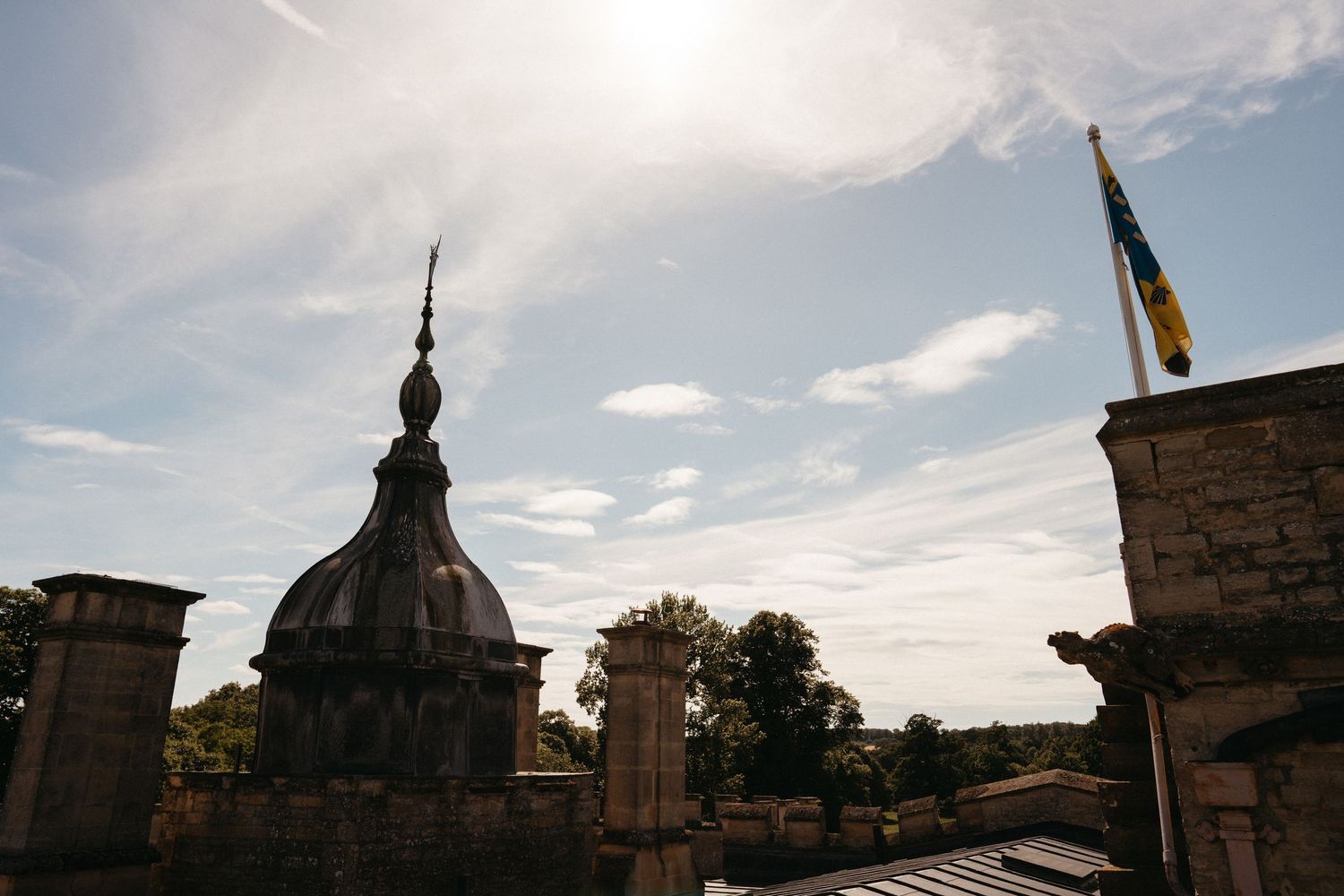 Architectural silhouettes of castle turrets and spires against a bright summer sky.