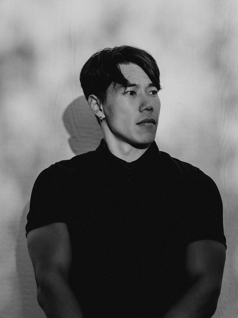 Dramatic black and white portrait with side lighting against a textured background.