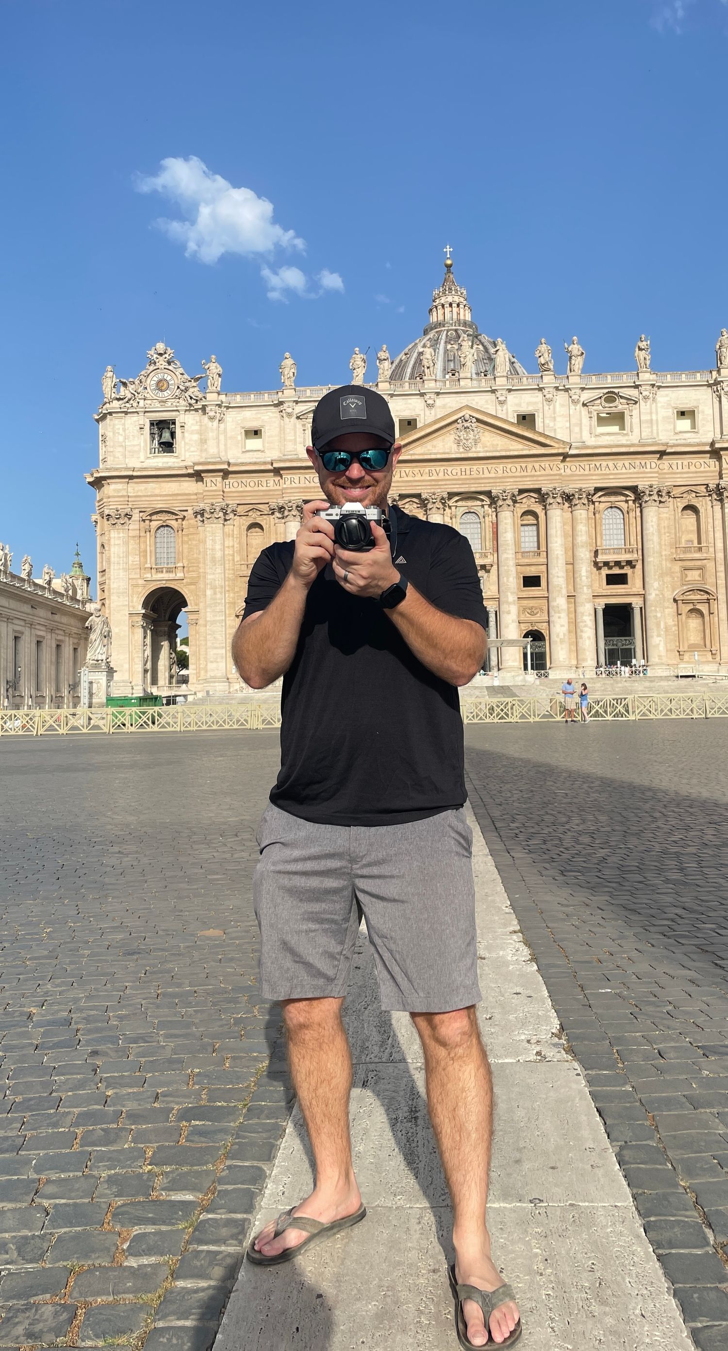 Tourist taking photo in front of St Peters Basilica in Vatican City.