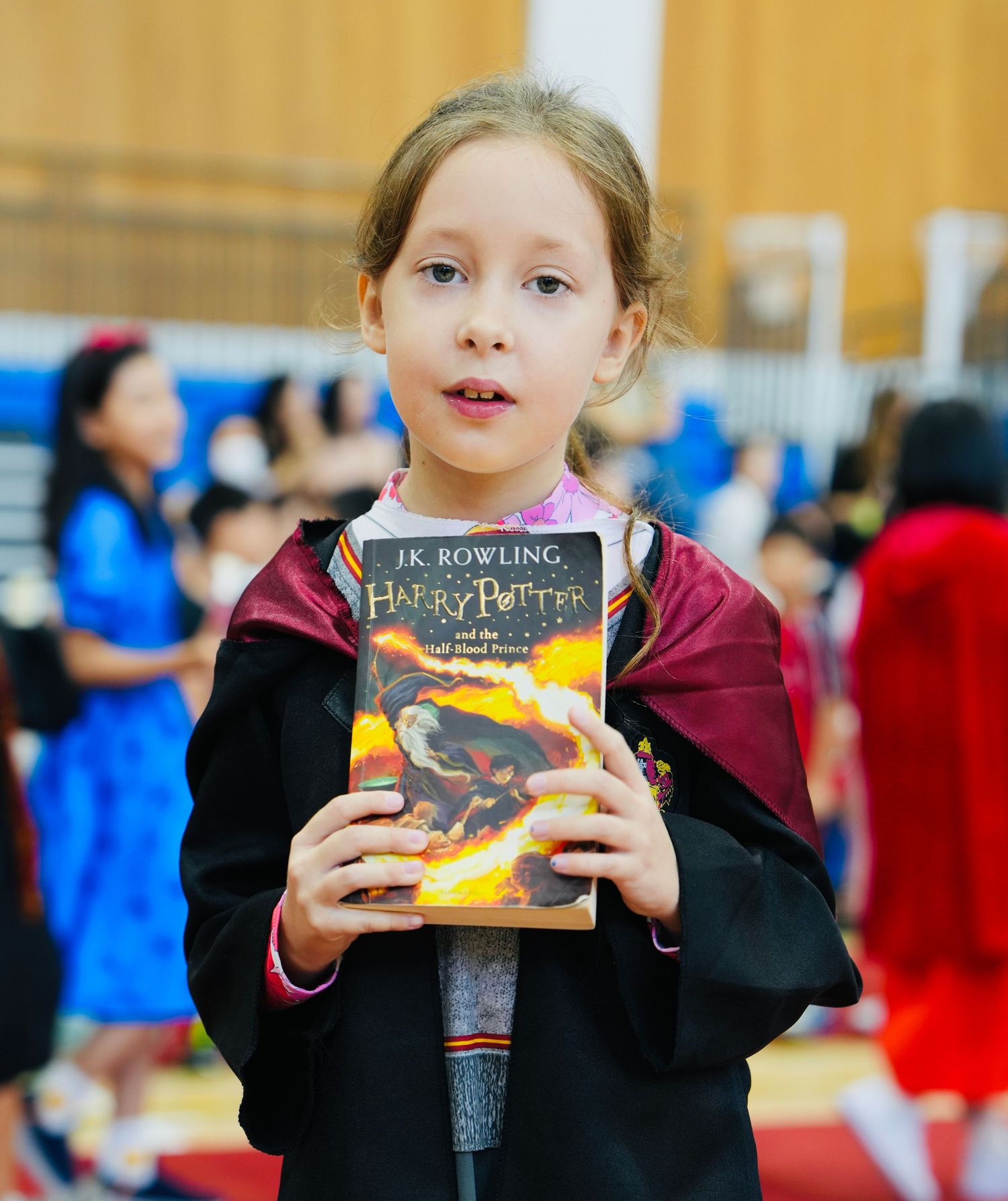 Student holding a Harry Potter book during a book-themed school presentation.