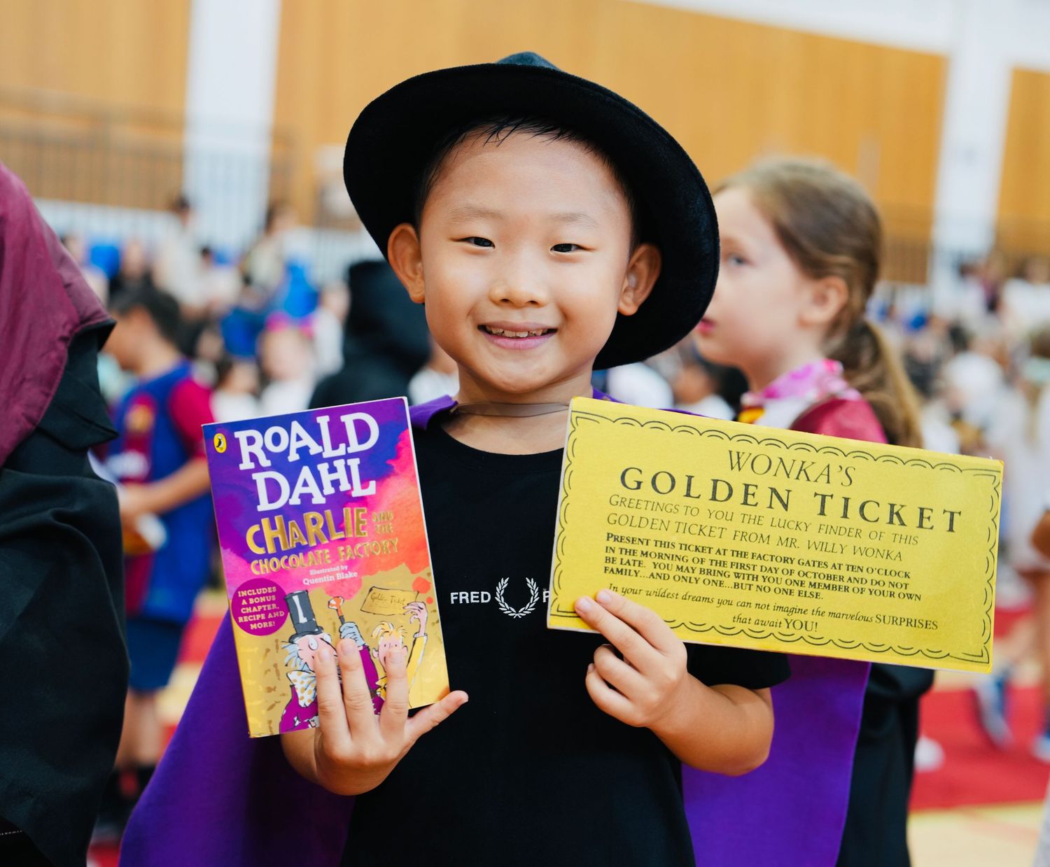 Children display classic literature props including a golden ticket and Roald Dahl books.
