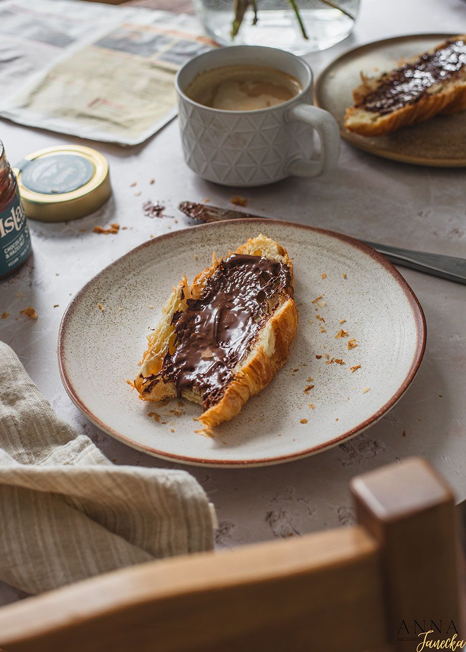 Slices of toasted bread topped with melted chocolate spread on white ceramic plates.