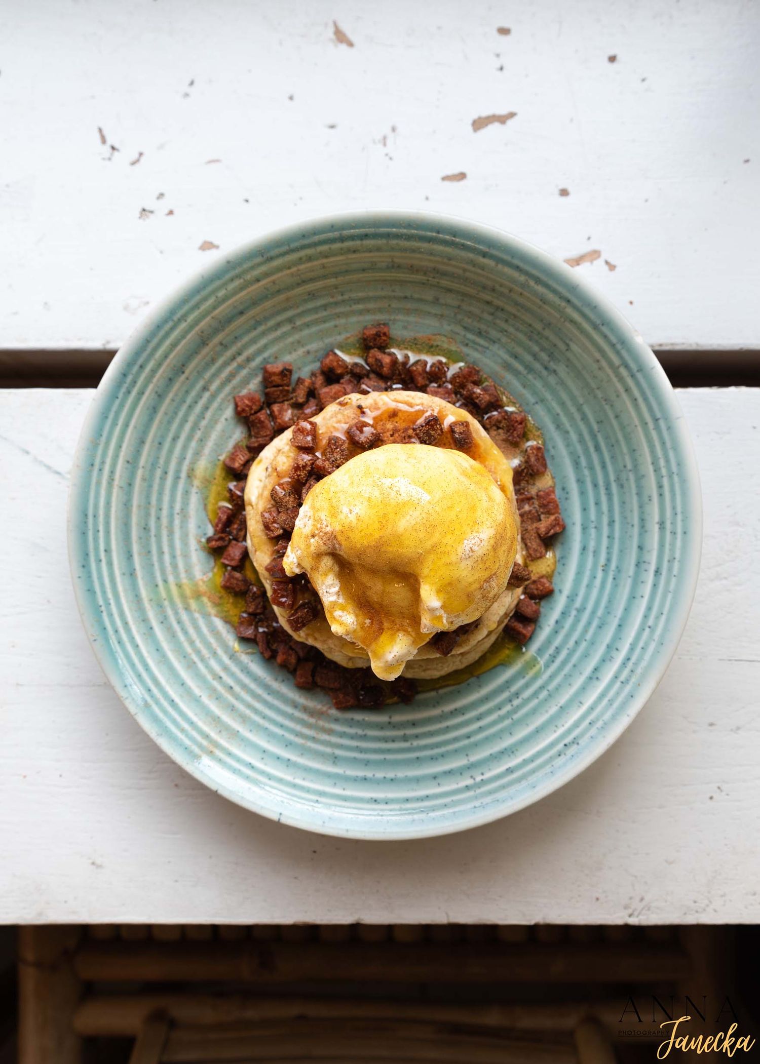 A gourmet burger topped with a sunny-side up egg served on a light blue ceramic plate.