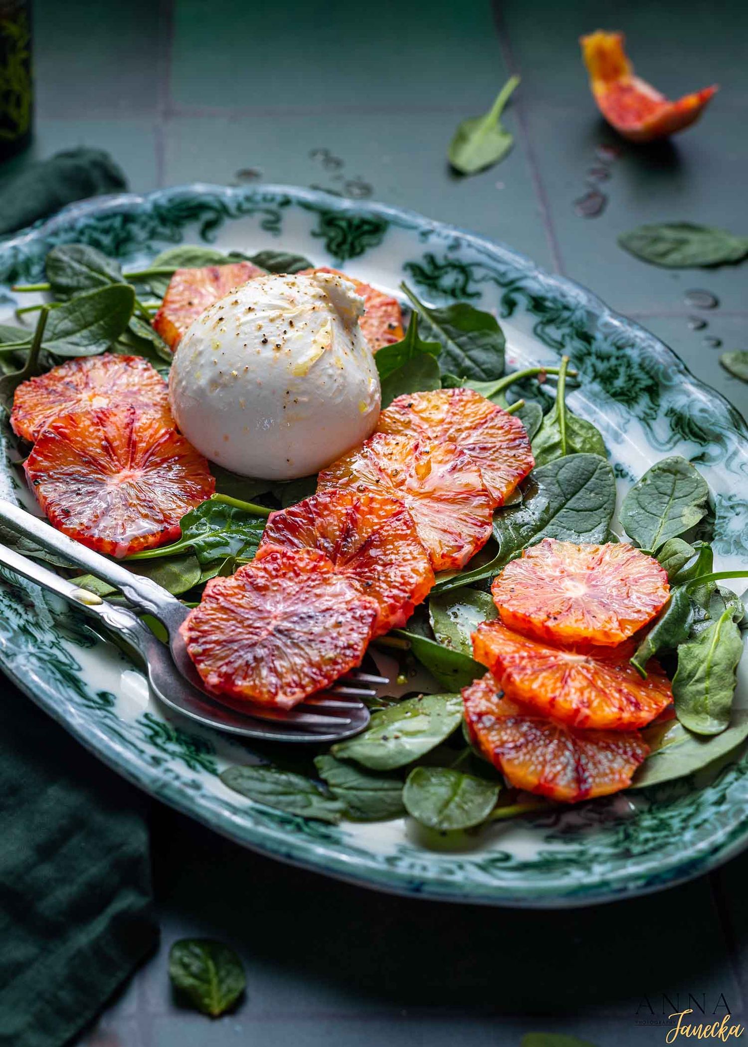 Grilled blood orange slices with poached egg on green salad leaves.