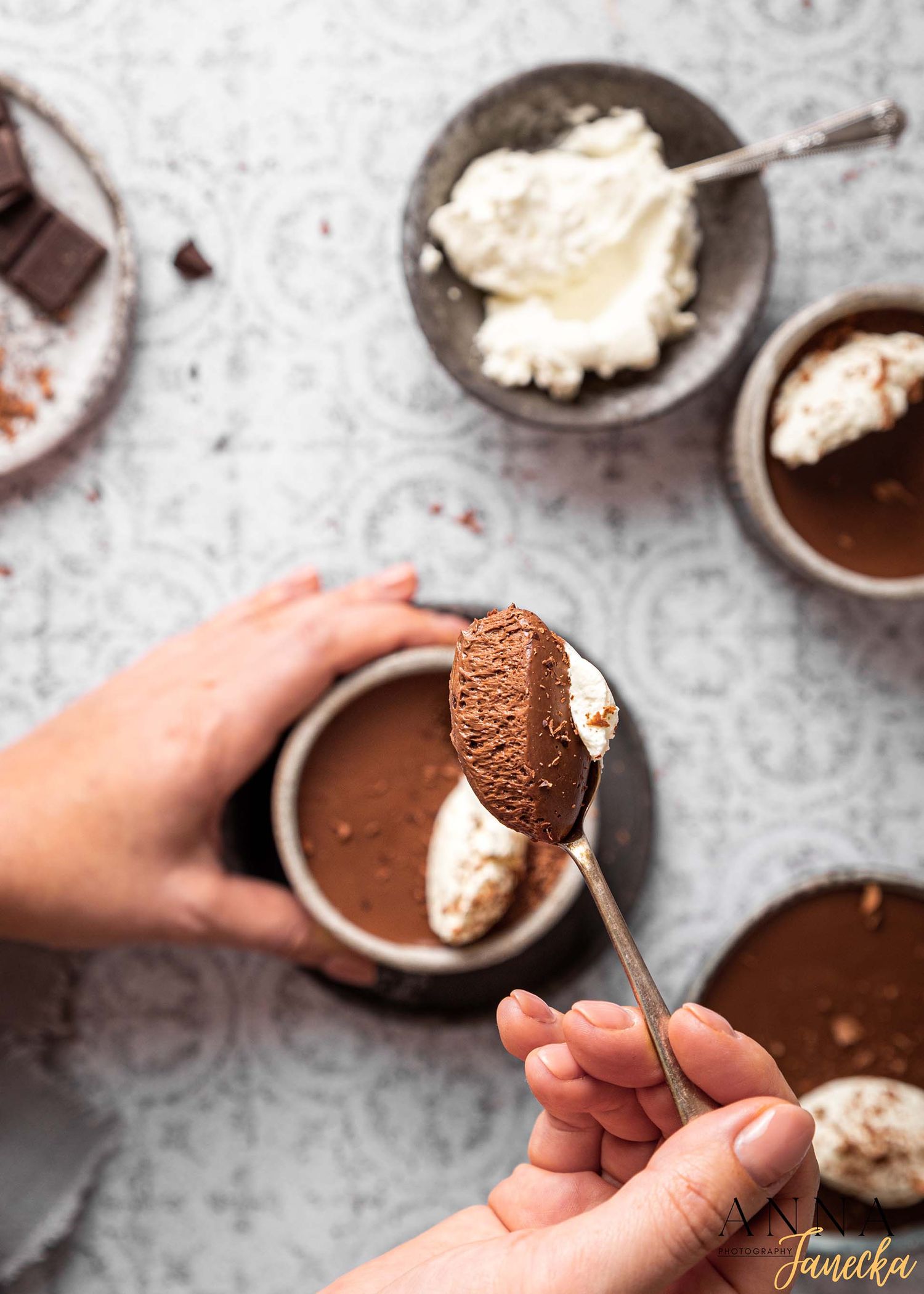 Chocolate desserts with whipped cream being dipped into dark chocolate sauce.