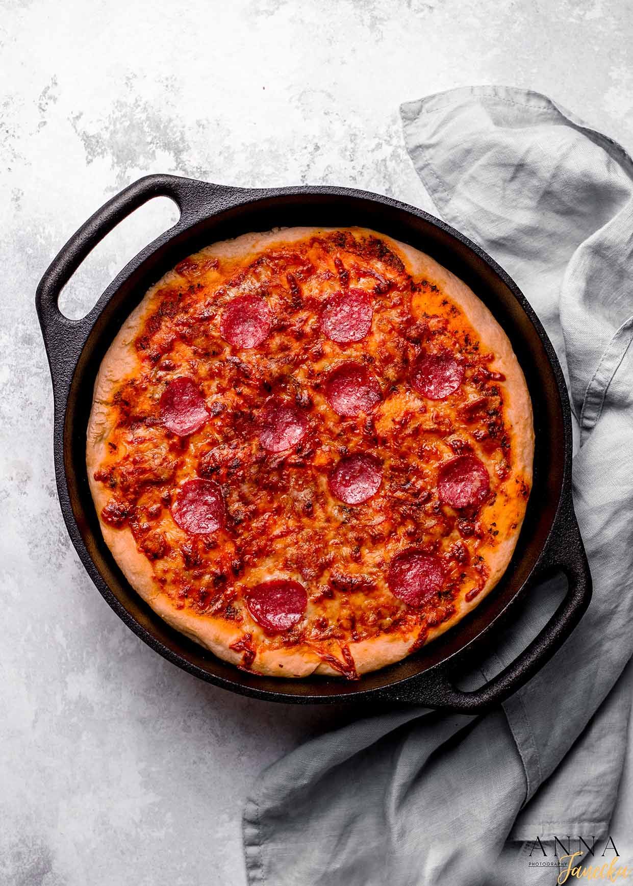 Pepperoni pizza with melted cheese baked in a cast iron skillet.