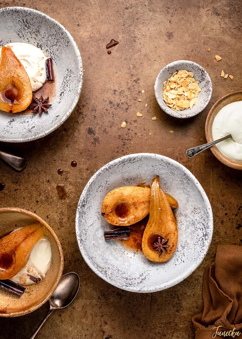 Poached pears in spiced syrup served with cinnamon sticks and star anise.