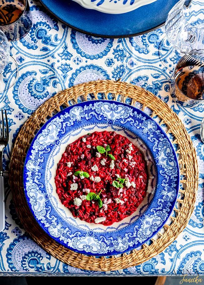 Fresh cranberry relish garnished with mint leaves served on a decorative blue and white plate with woven placemat.