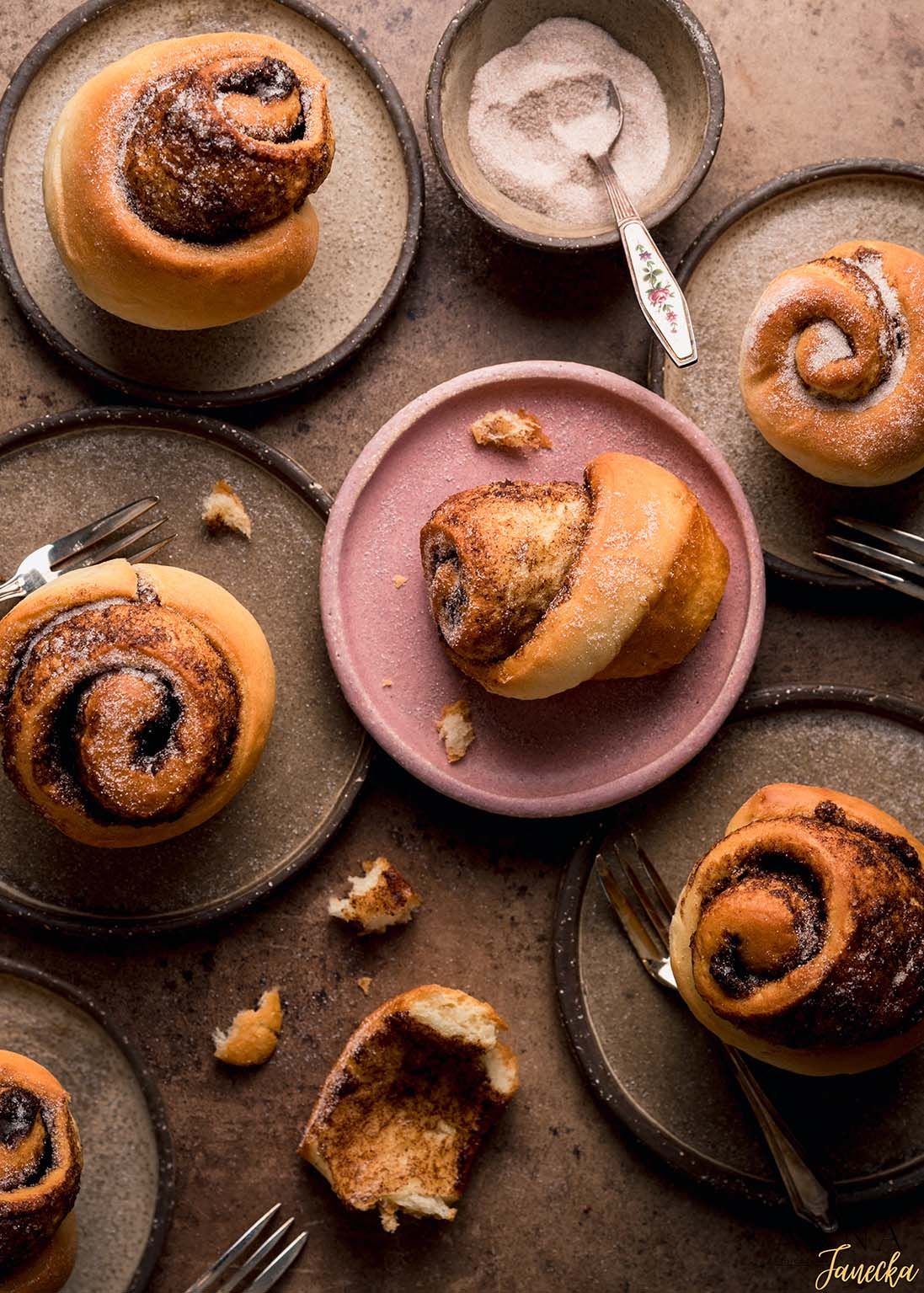 Freshly baked chocolate swirl buns arranged on dark rustic plates.